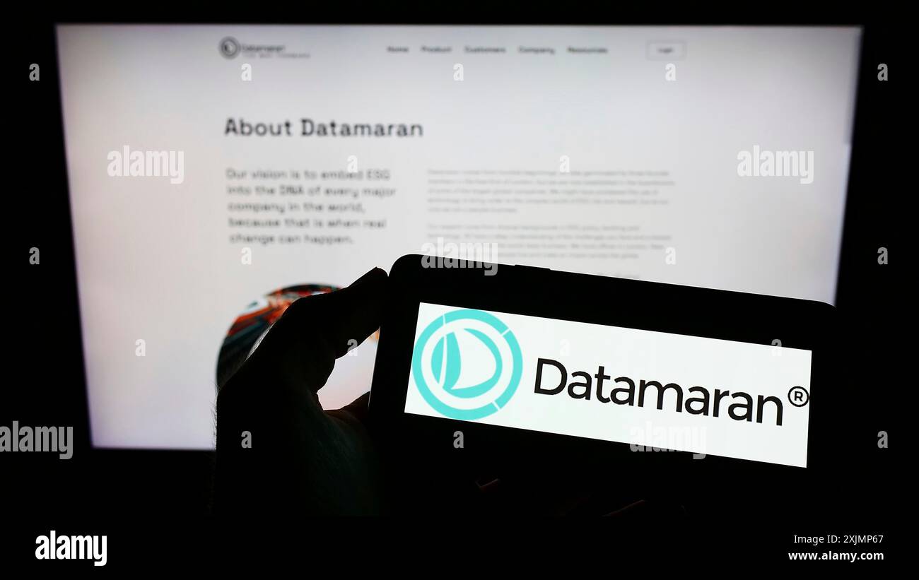 Stuttgart, Allemagne, 09-25-2022, personne tenant un téléphone portable avec le logo de la société britannique de logiciels ESG Datamaran Ltd sur l'écran en face de la page Web. Banque D'Images