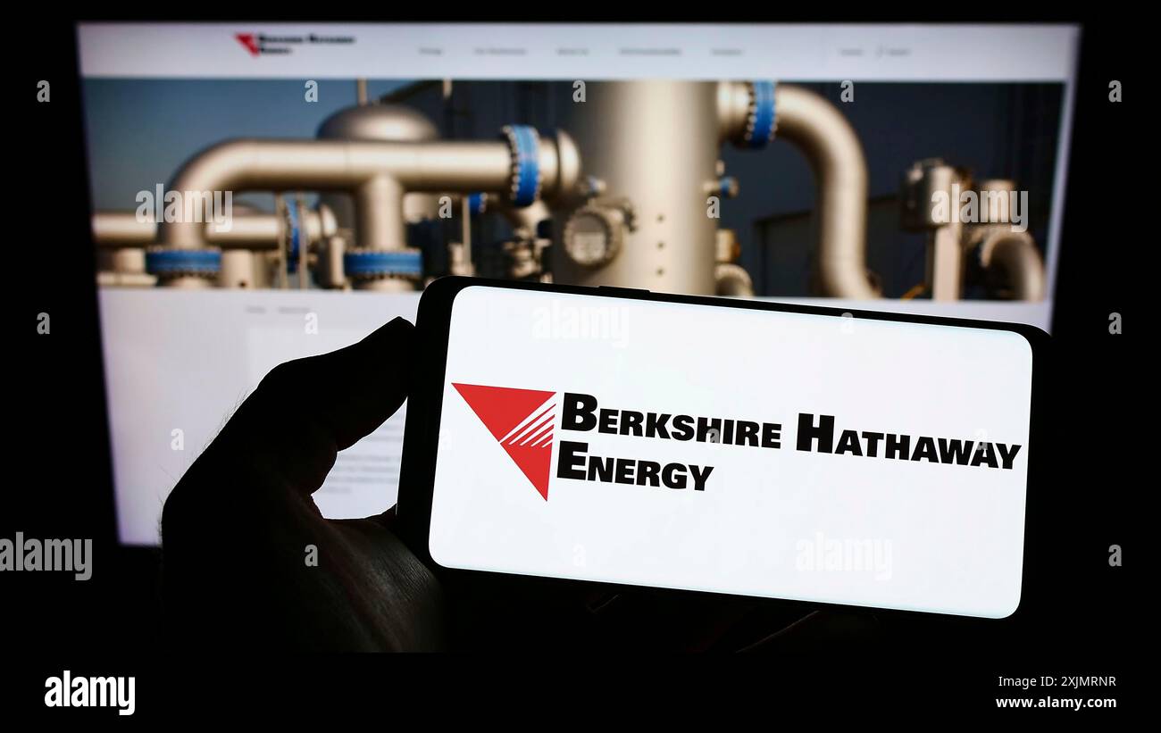 Stuttgart, Allemagne, 10-13-2022 : personne tenant un téléphone portable avec le logo de la société américaine Berkshire Hathaway Energy sur l'écran en face de la page Web de l'entreprise. Banque D'Images
