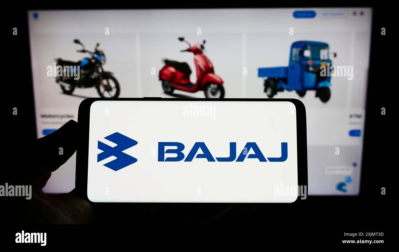 Stuttgart, Allemagne, 10-15-2022 : personne tenant un téléphone portable avec le logo de la société automobile indienne Bajaj Auto Limited sur l'écran devant la page Web. Banque D'Images