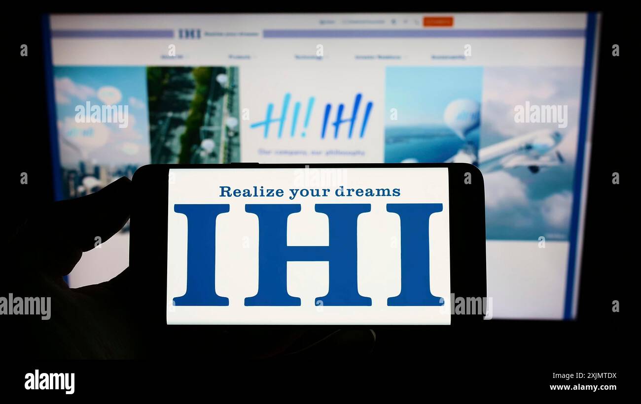 Stuttgart, Allemagne, 10 26 2022 : personne tenant un téléphone portable avec le logo de la société d'ingénierie japonaise IHI Corporation sur l'écran en face de la page Web. Banque D'Images