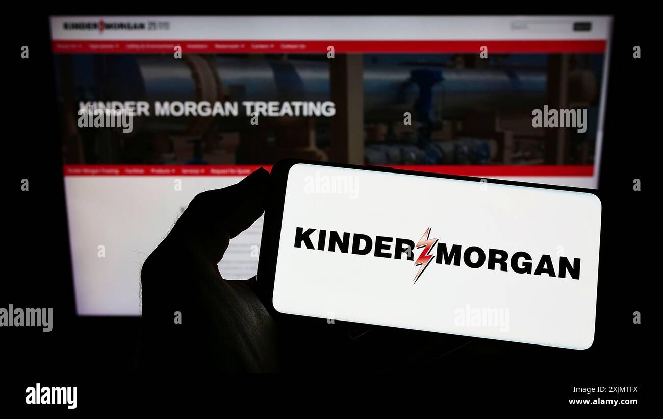 Stuttgart, Allemagne, 10 27 2022 : personne tenant un téléphone portable avec le logo de la société énergétique américaine Kinder Morgan Inc sur l'écran devant la page Web de l'entreprise. Banque D'Images