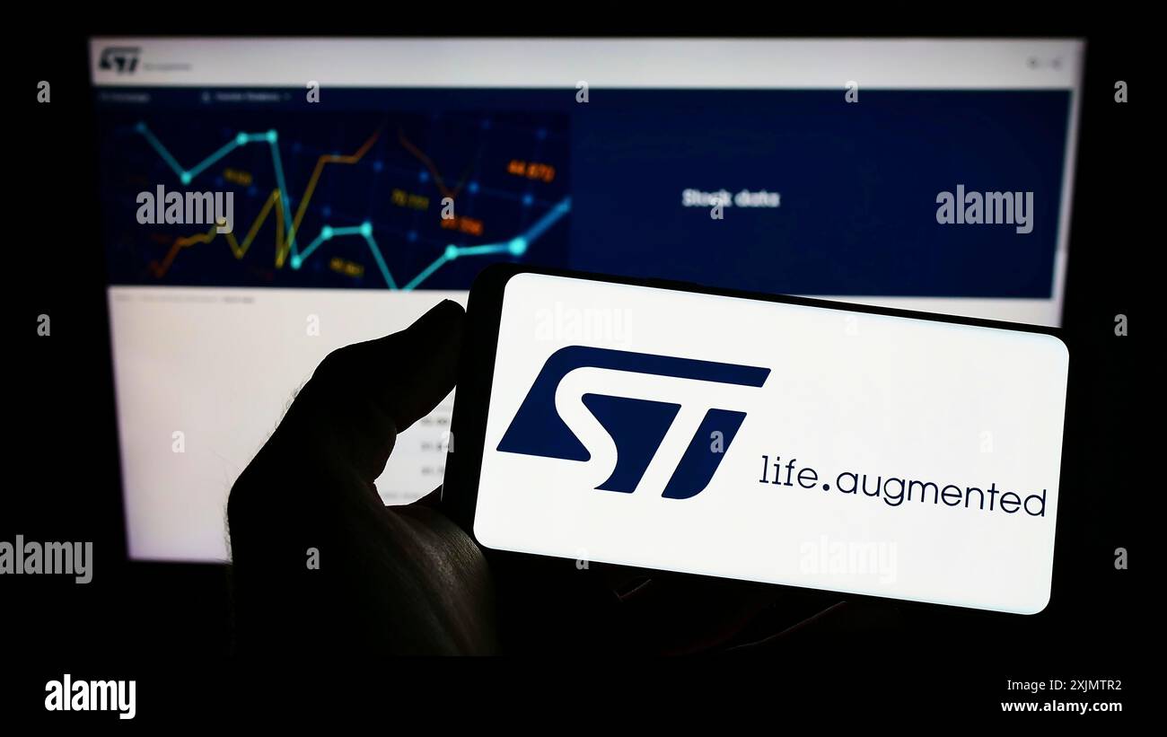 Stuttgart, Allemagne, 10 30 2022 : personne tenant un téléphone portable avec le logo de la société de semi-conducteurs STMicroelectronics N.V. sur l'écran devant le web Banque D'Images