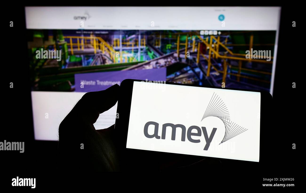 Stuttgart, Allemagne, 10-23-2022 : personne tenant un téléphone portable avec le logo de la société d'infrastructure britannique Amey plc sur l'écran devant la page Web de l'entreprise. Banque D'Images