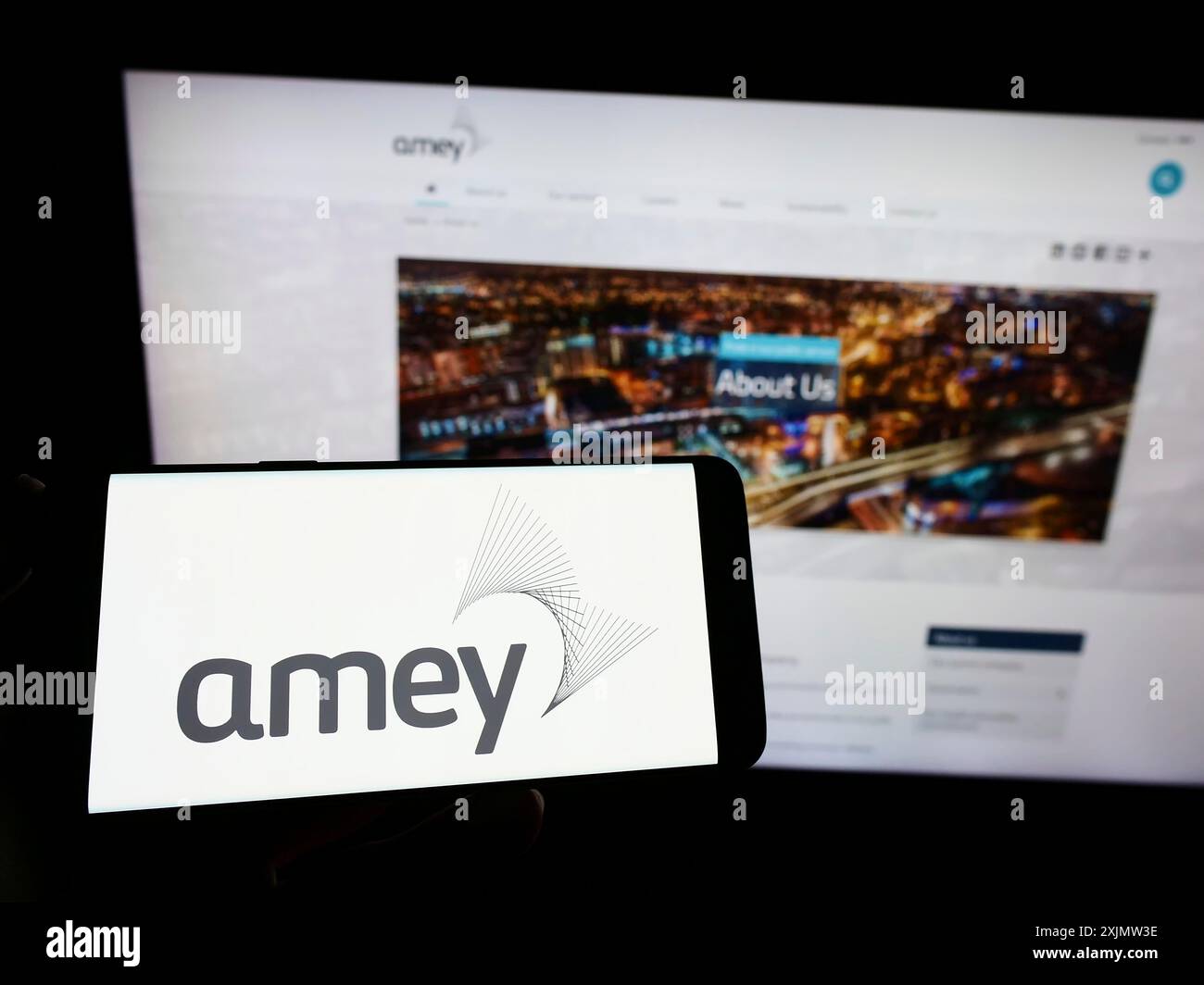 Stuttgart, Allemagne, 10-23-2022 : personne tenant un smartphone avec le logo de la société d'infrastructure britannique Amey plc sur l'écran devant le site Web. Mise au point Banque D'Images
