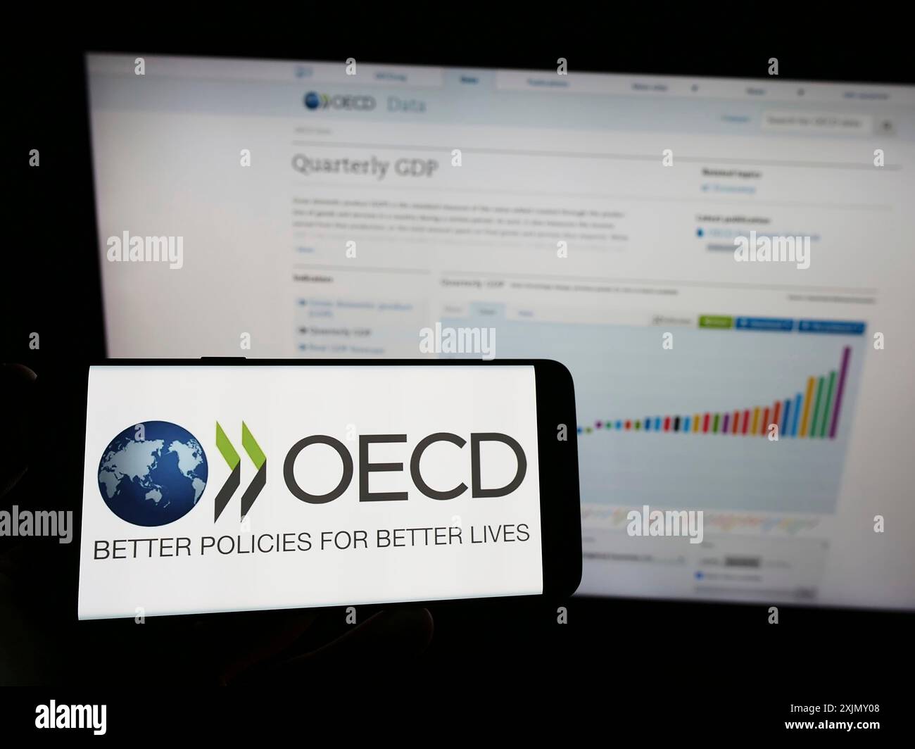 Stuttgart, Allemagne, 12-23-2022 : personne tenant un smartphone avec le logo de l'organisation intergouvernementale OCDE sur l'écran devant le site web. Concentrez-vous sur Banque D'Images