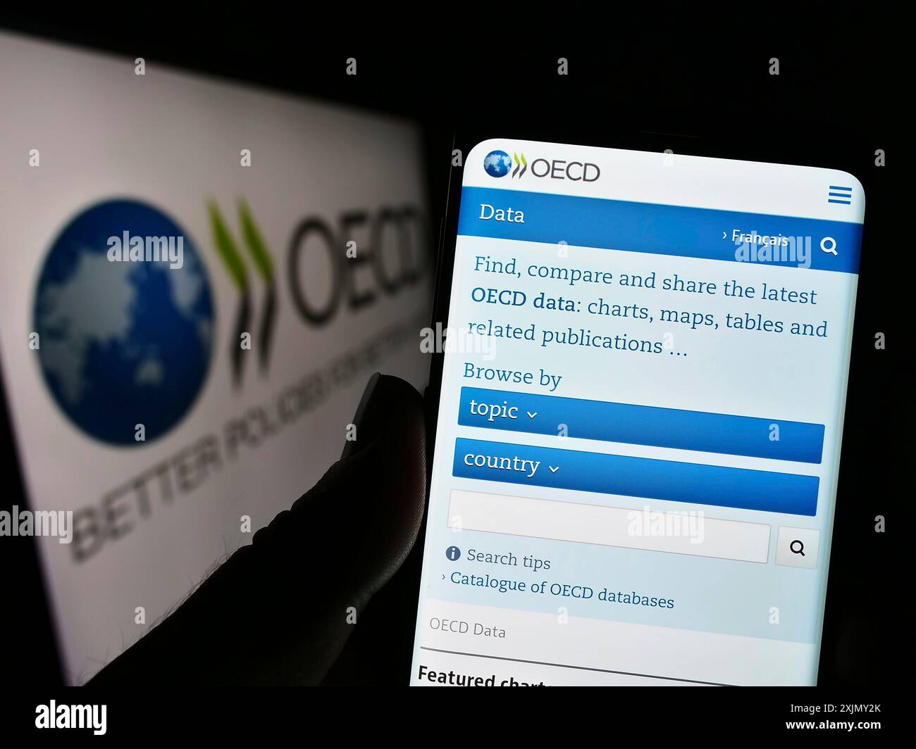 Stuttgart, Allemagne, 12-23-2022 : personne tenant un téléphone portable avec la page web de l'organisation intergouvernementale OCDE sur l'écran devant le logo. Concentrez-vous sur Banque D'Images
