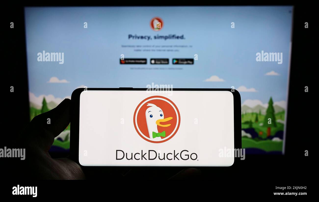 Stuttgart, Allemagne, 01-14-2023 : personne tenant un téléphone portable avec le logo du moteur de recherche Internet DuckDuckGo (DDG) sur l'écran devant le site Web de l'entreprise Banque D'Images