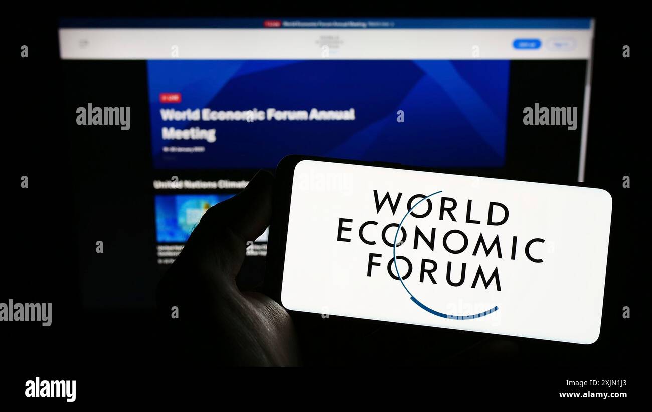Stuttgart, Allemagne, 01-21-2023 : personne tenant un smartphone avec le logo de l'organisation World Economic Forum (WEF) sur l'écran devant le site Web. Mise au point Banque D'Images