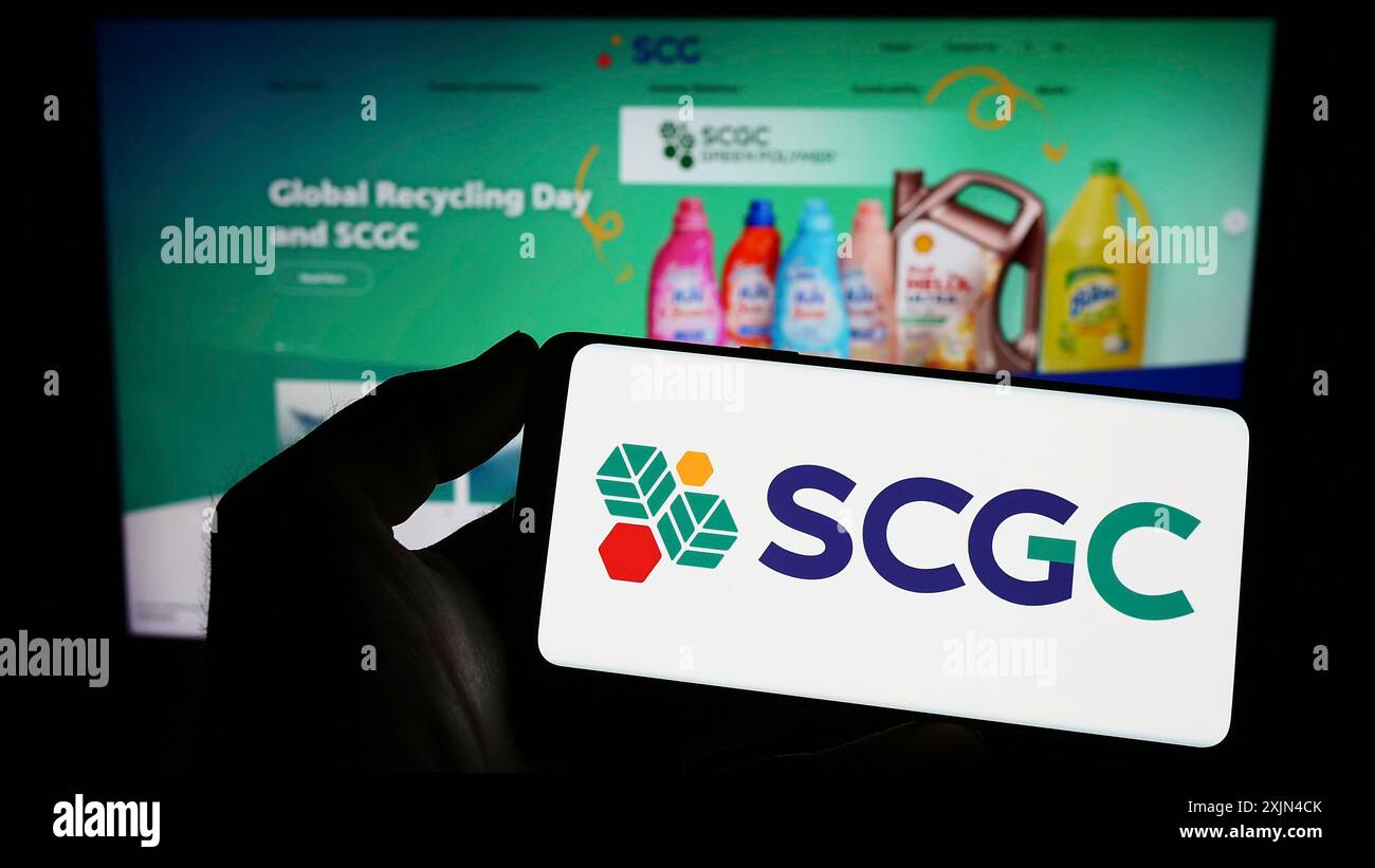 Stuttgart, Allemagne, 03-31-2023, personne tenant un téléphone portable avec le logo de la société thaïlandaise SCG Chemicals (SCGC) sur l'écran devant la page Web de l'entreprise. Banque D'Images