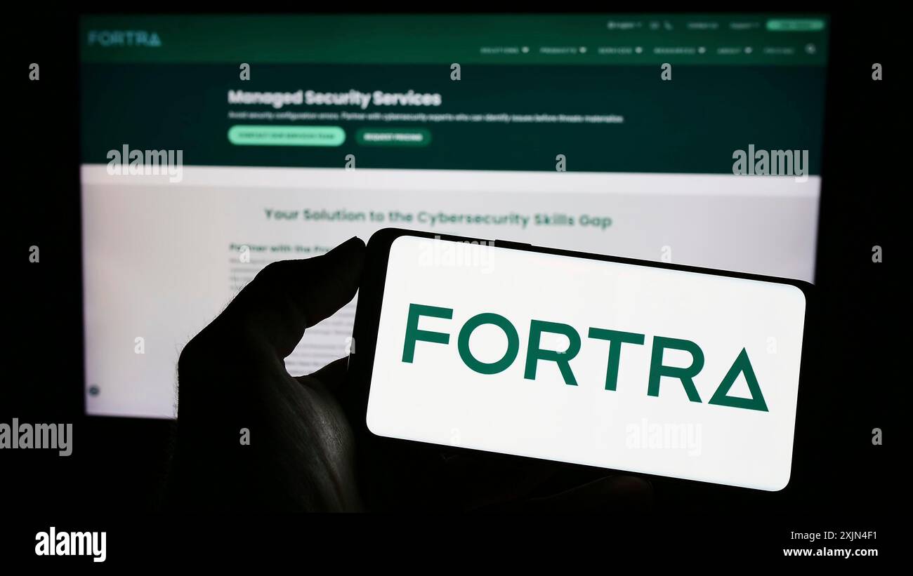 Stuttgart, Allemagne, 04-01-2023 : personne tenant un smartphone avec le logo de la société américaine de cybersécurité Fortra LLC sur l'écran devant le site Web. Concentrez-vous sur Banque D'Images