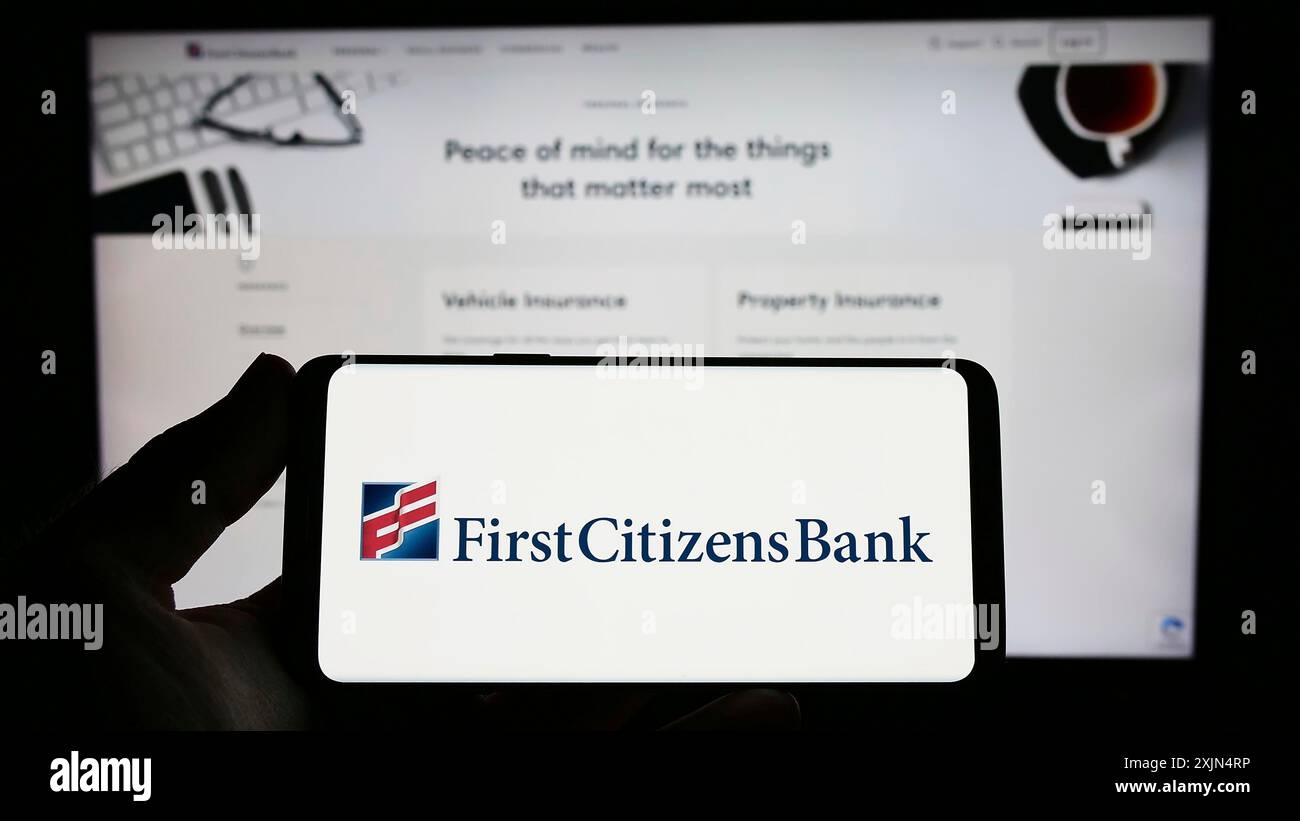 Stuttgart, Allemagne, 04-02-2023 : personne tenant un smartphone avec le logo de la société financière américaine First Citizens Bank sur l'écran devant le site Web. Mise au point Banque D'Images