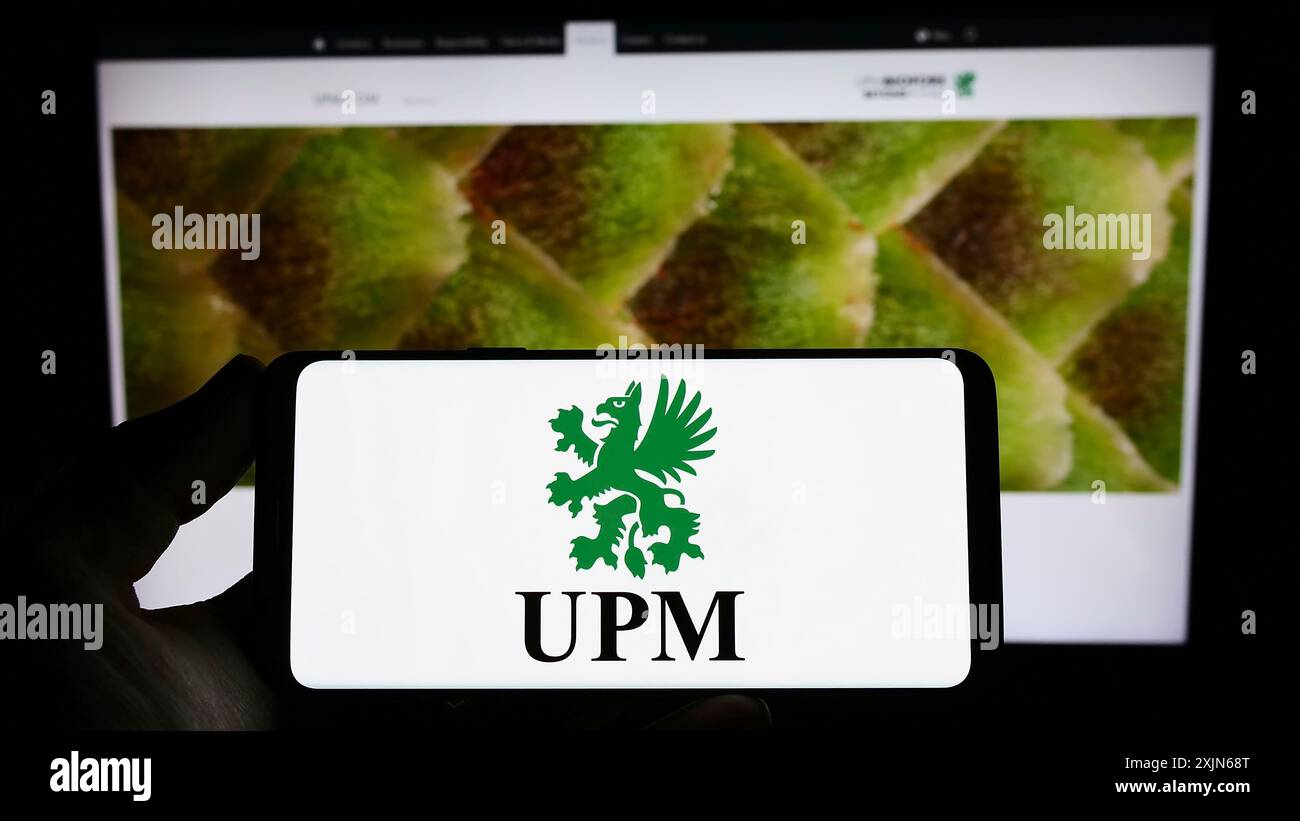 Stuttgart, Allemagne, 03-31-2023, personne tenant un smartphone avec le logo de l'entreprise forestière finlandaise UPM-Kymmene Oyj sur l'écran devant le site Web. Mise au point Banque D'Images