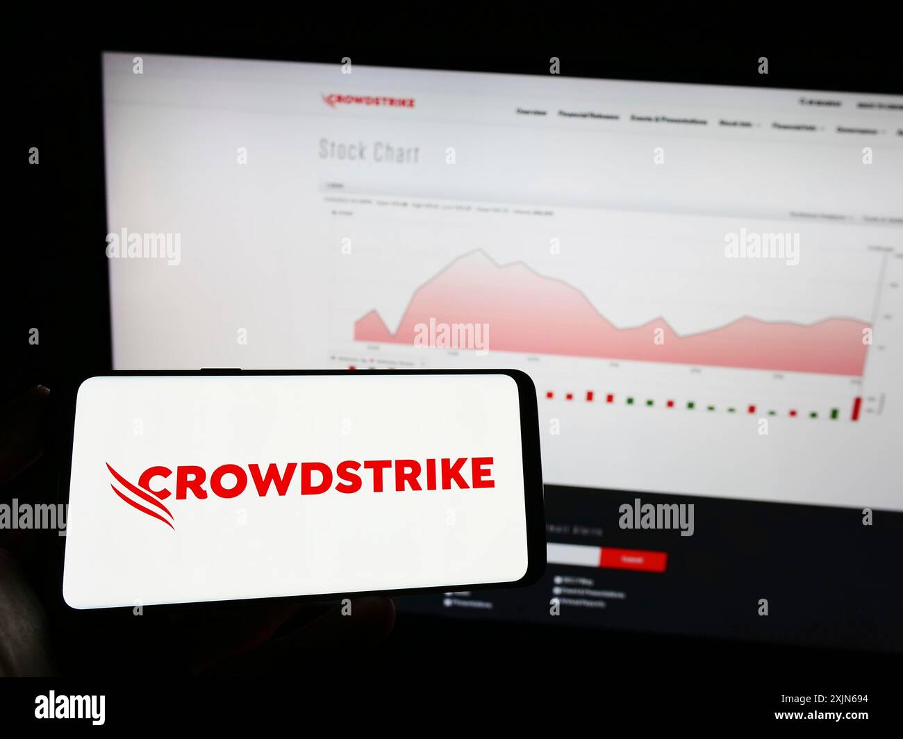 Stuttgart, Allemagne, 03-31-2023, personne tenant un téléphone portable avec le logo de la société de cybersécurité CrowdStrike Holdings Inc. sur l'écran devant le web Banque D'Images