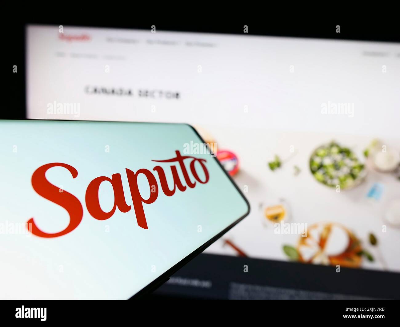 Stuttgart, Allemagne, 06-18-2023 : smartphone avec le logo de la société laitière canadienne Saputo Inc sur l'écran devant le site Web de l'entreprise. Concentrez-vous sur le centre de Banque D'Images