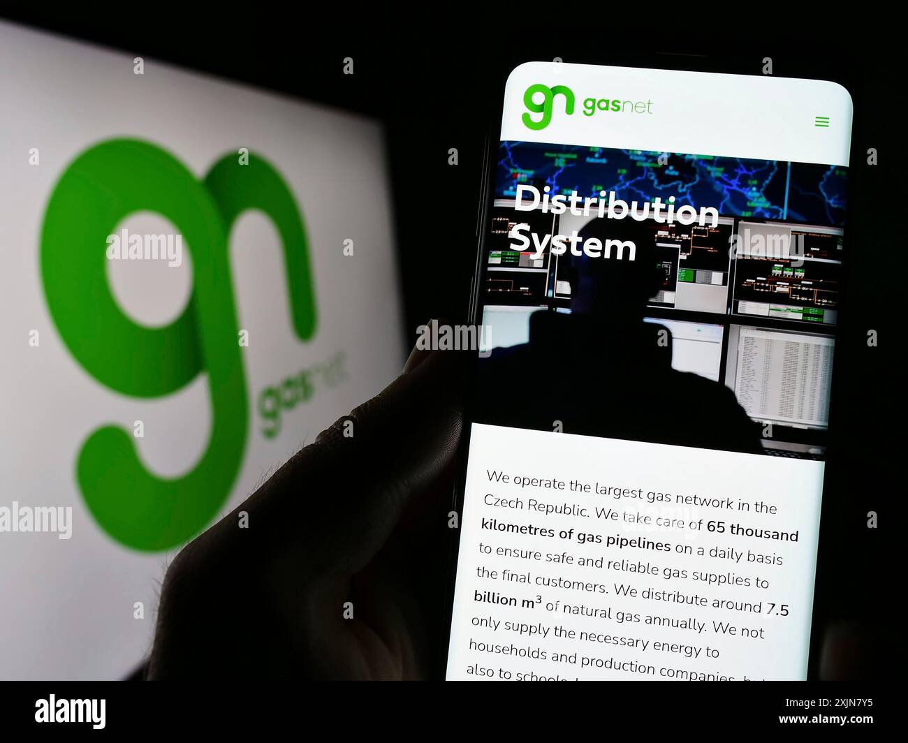 Stuttgart, Allemagne, 06-18-2023 : personne tenant un téléphone portable avec la page web de la société tchèque de distribution de gaz GasNet s.r.o sur l'écran devant le logo. Banque D'Images
