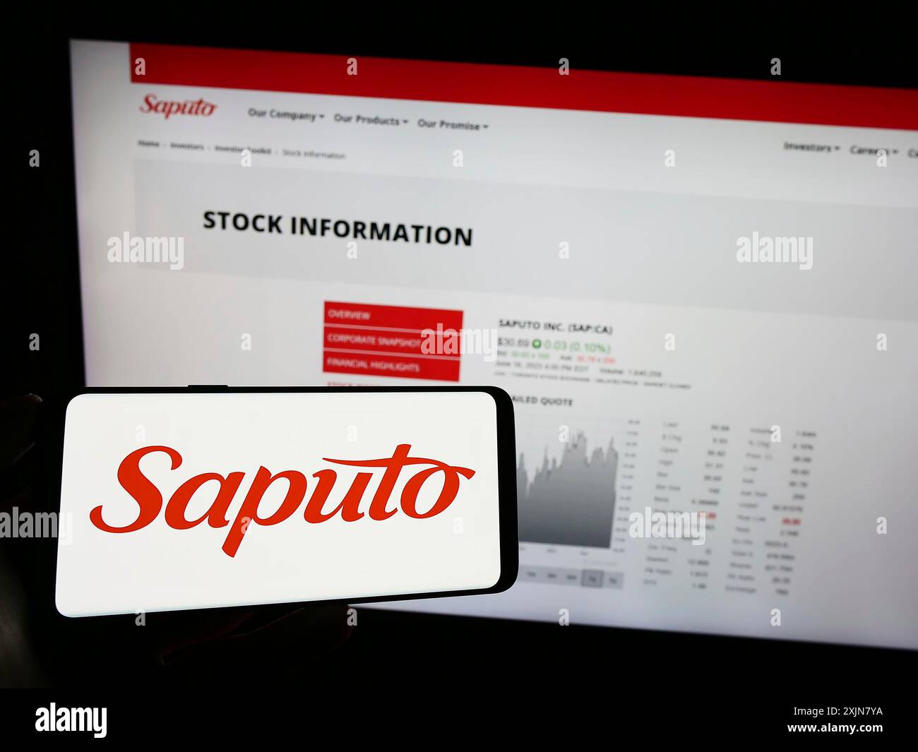 Stuttgart, Allemagne, 06-18-2023 : personne tenant un téléphone portable avec le logo de la société laitière canadienne Saputo Inc sur l'écran devant la page Web de l'entreprise. Banque D'Images