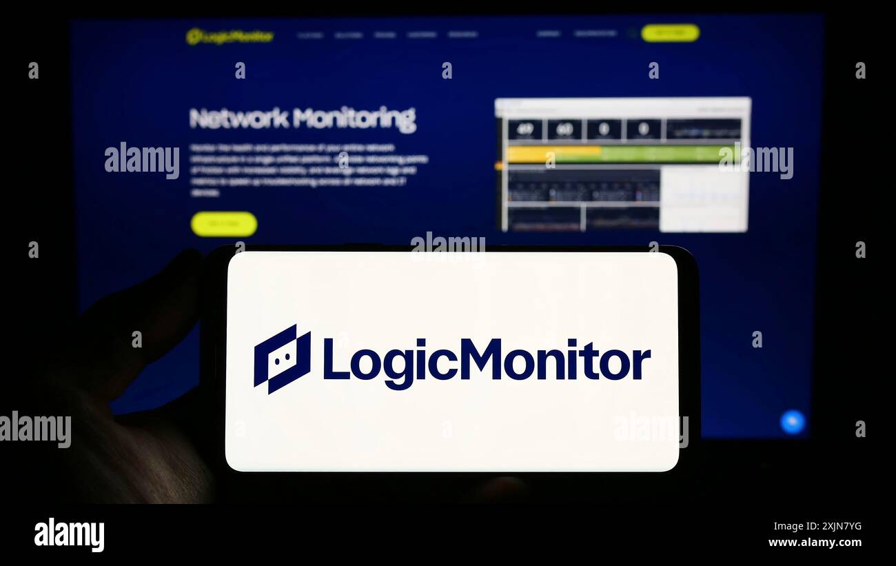 Stuttgart, Allemagne, 06-18-2023 : personne tenant un smartphone avec le logo de la société de surveillance américaine LogicMonitor Inc. sur l'écran devant le site Web. Mise au point Banque D'Images