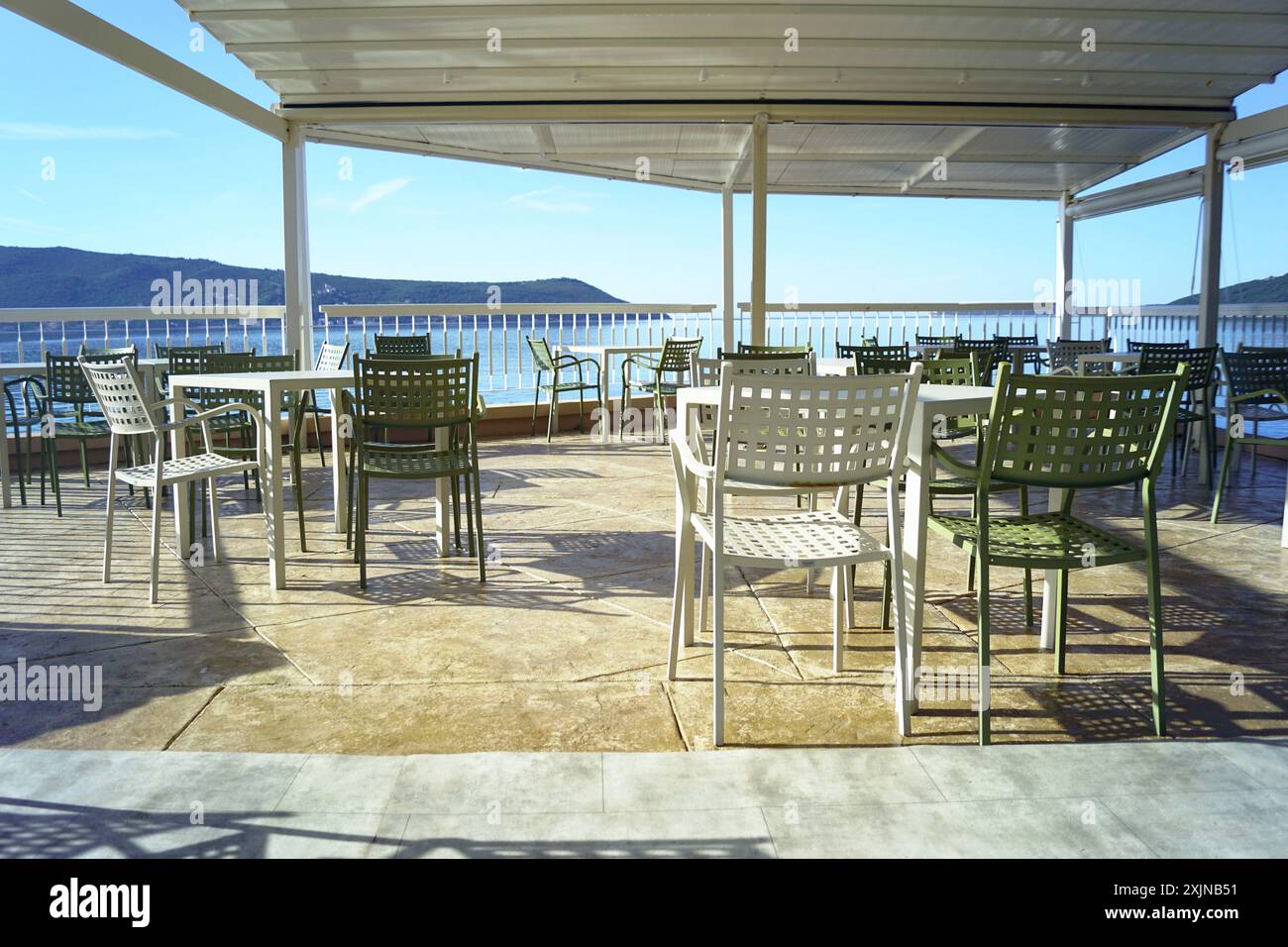 Une terrasse de café sans clients. Vacances sur la mer Méditerranée en dehors de la saison touristique - photo de la promenade de Herceg Novi, Monténégro. Banque D'Images