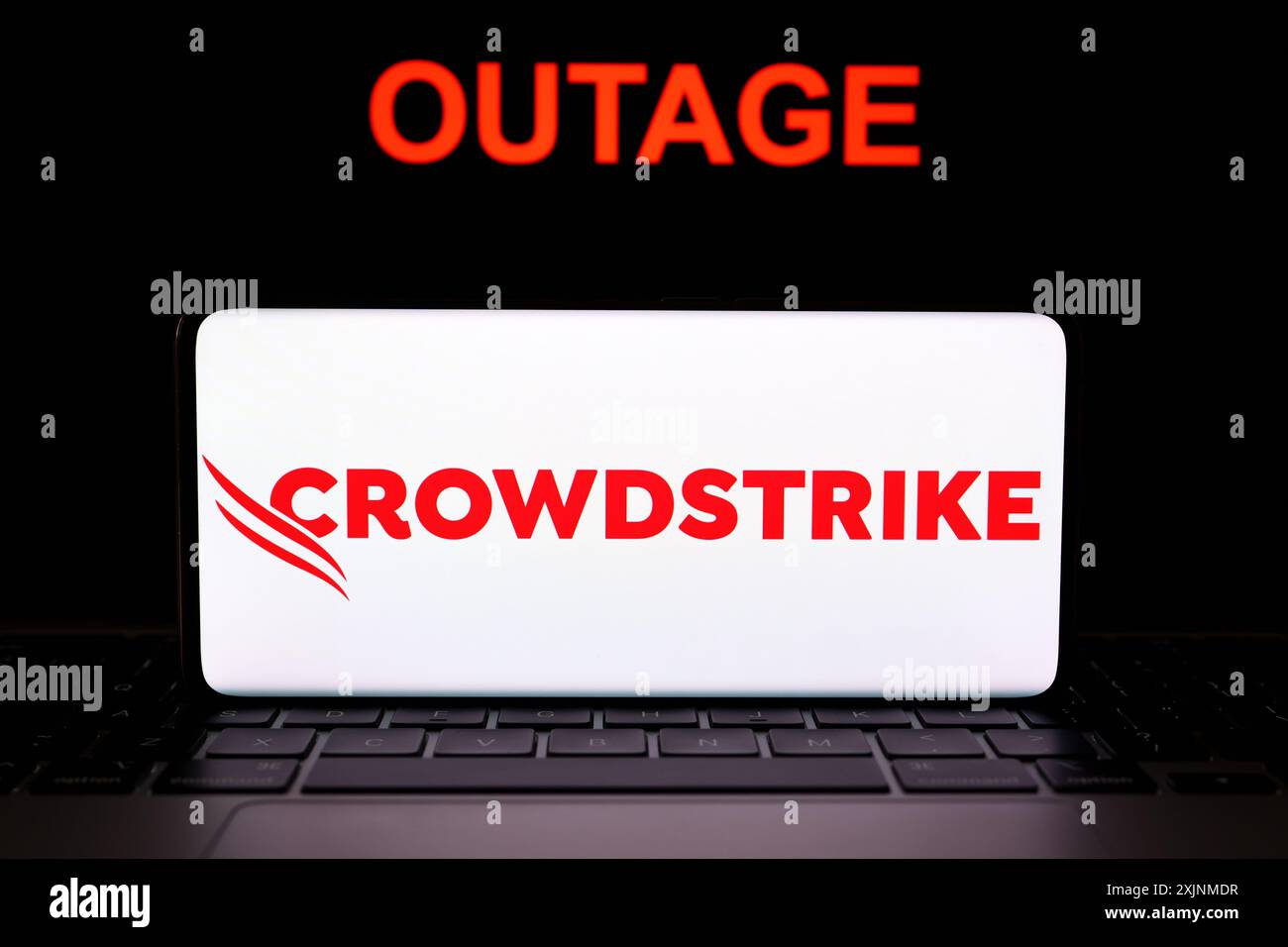 Logo CrowdStrike vu sur l'écran du smartphone et le mot PANNE vu derrière. Entreprise de cybersécurité derrière la panne INFORMATIQUE mondiale. Concept. Stafford Banque D'Images