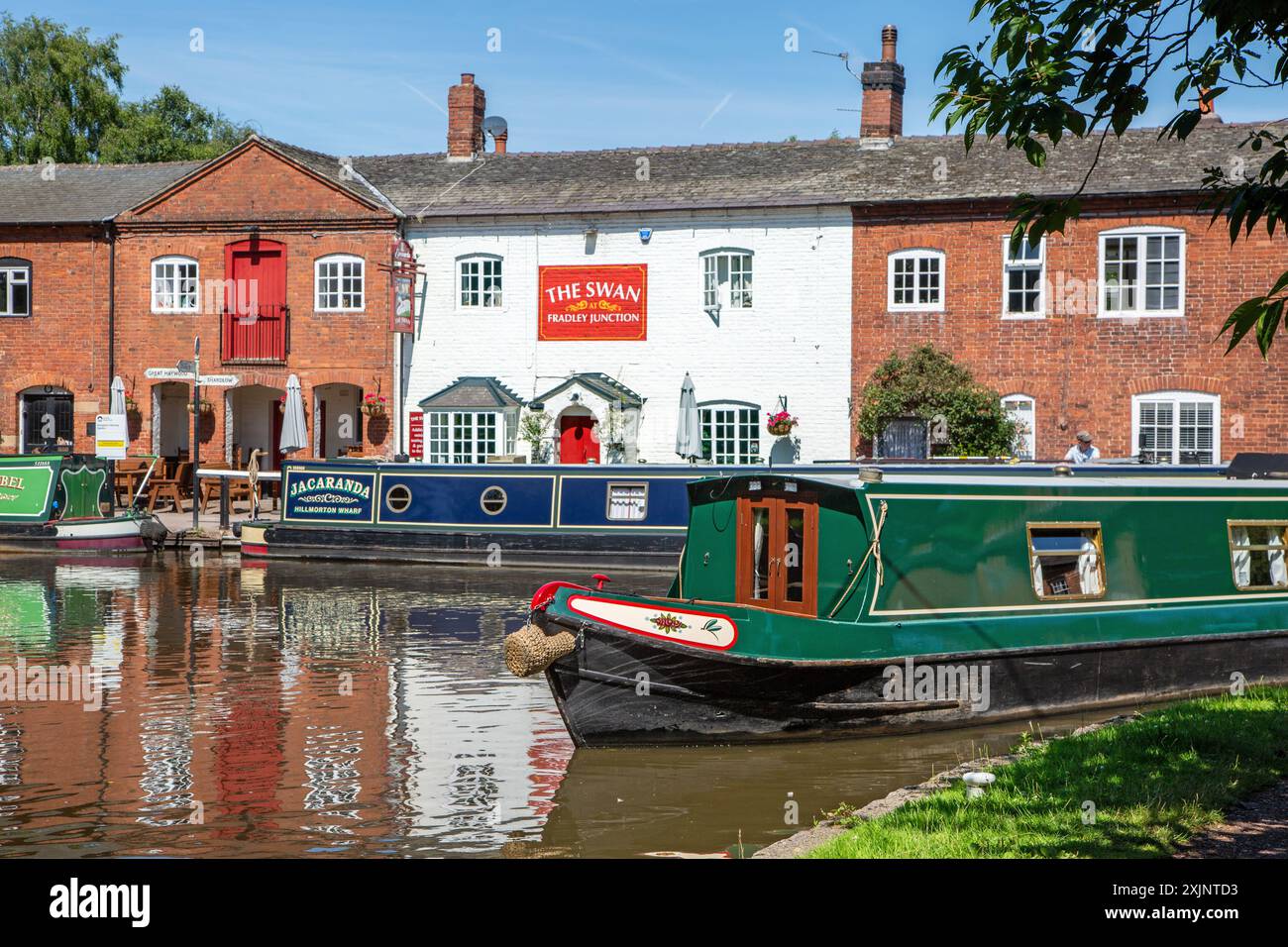 Bateau étroit quittant le canal Trent and Mersey canal à Fradley Junction Staffordshire, pour rejoindre le canal de Coventry par la maison publique Swan inn Banque D'Images