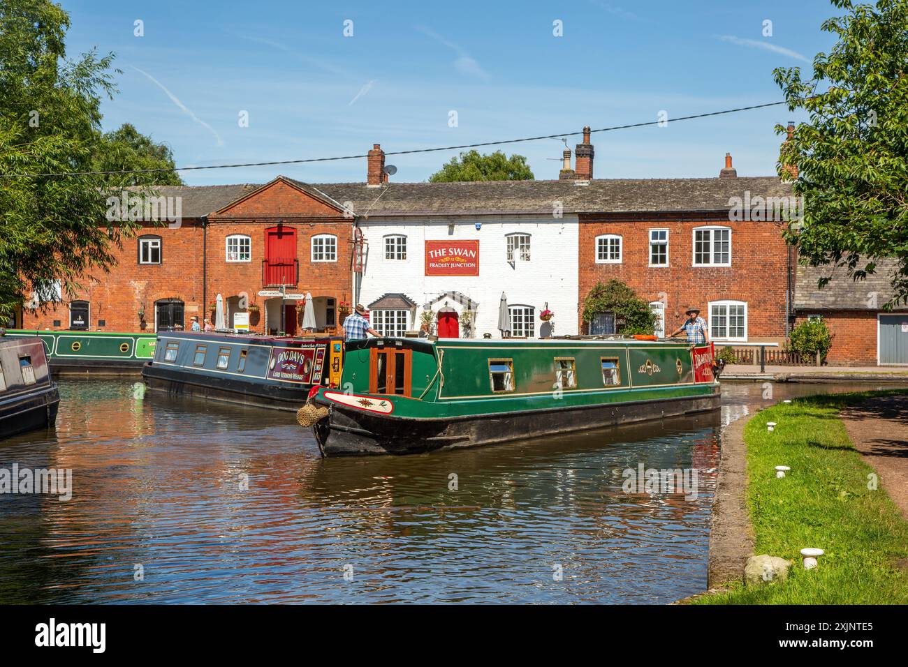 Bateaux étroits à Fradley Junction Staffordshire, à la jonction des canaux Coventry et Trent et Mersey, avec le pub The Swan Banque D'Images