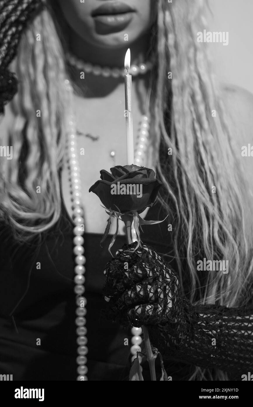 Photo gothique en noir et blanc avec bougie et rose. Banque D'Images