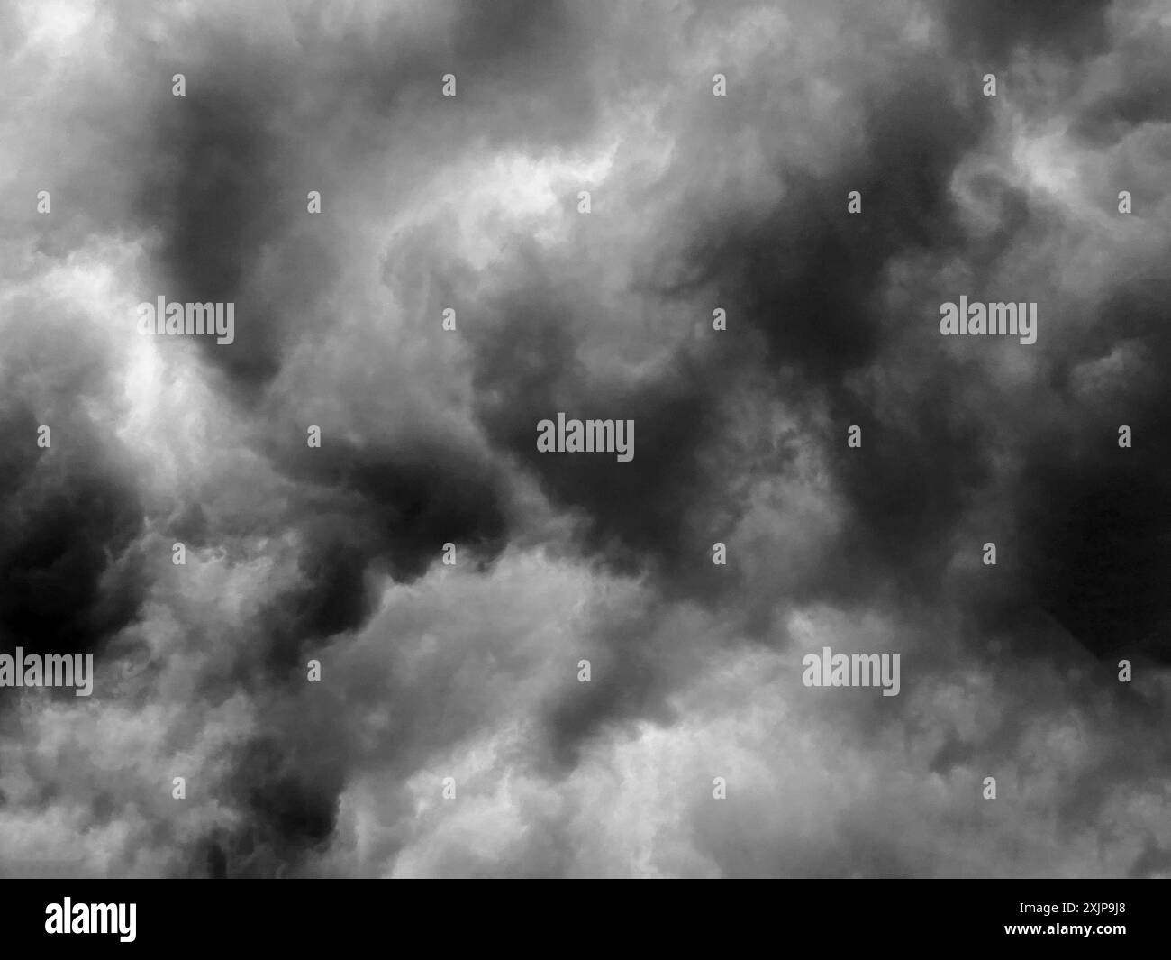 L'image montre un ciel rempli de nuages sombres et lourds. Les nuages sont très denses et créent une atmosphère dramatique et inquiétante. L'image est en noir Banque D'Images