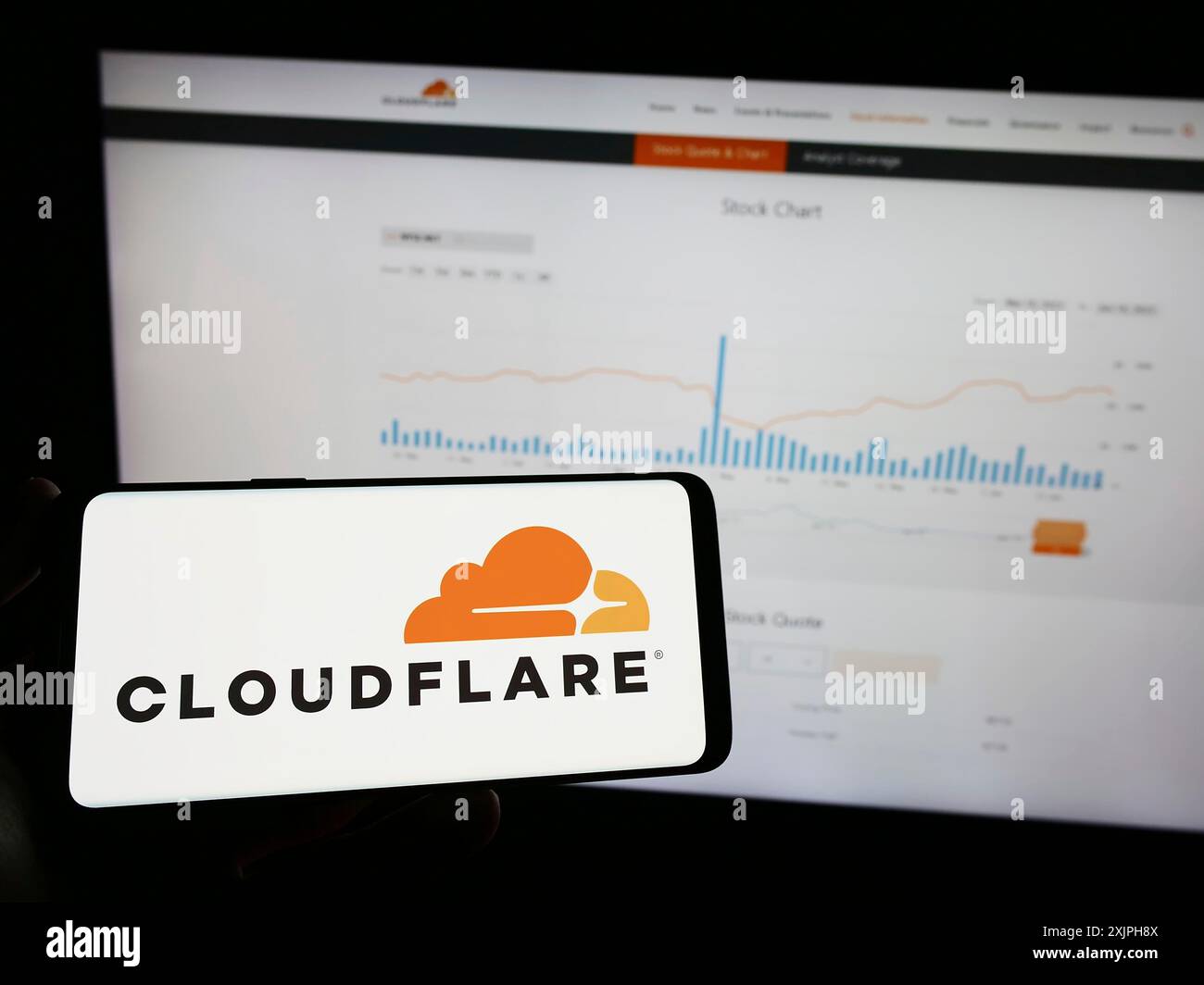 Stuttgart, Allemagne, 06-17-2023 : personne tenant un téléphone portable avec le logo de la société américaine de TIC Cloudflare Inc sur l'écran devant le web d'affaires Banque D'Images
