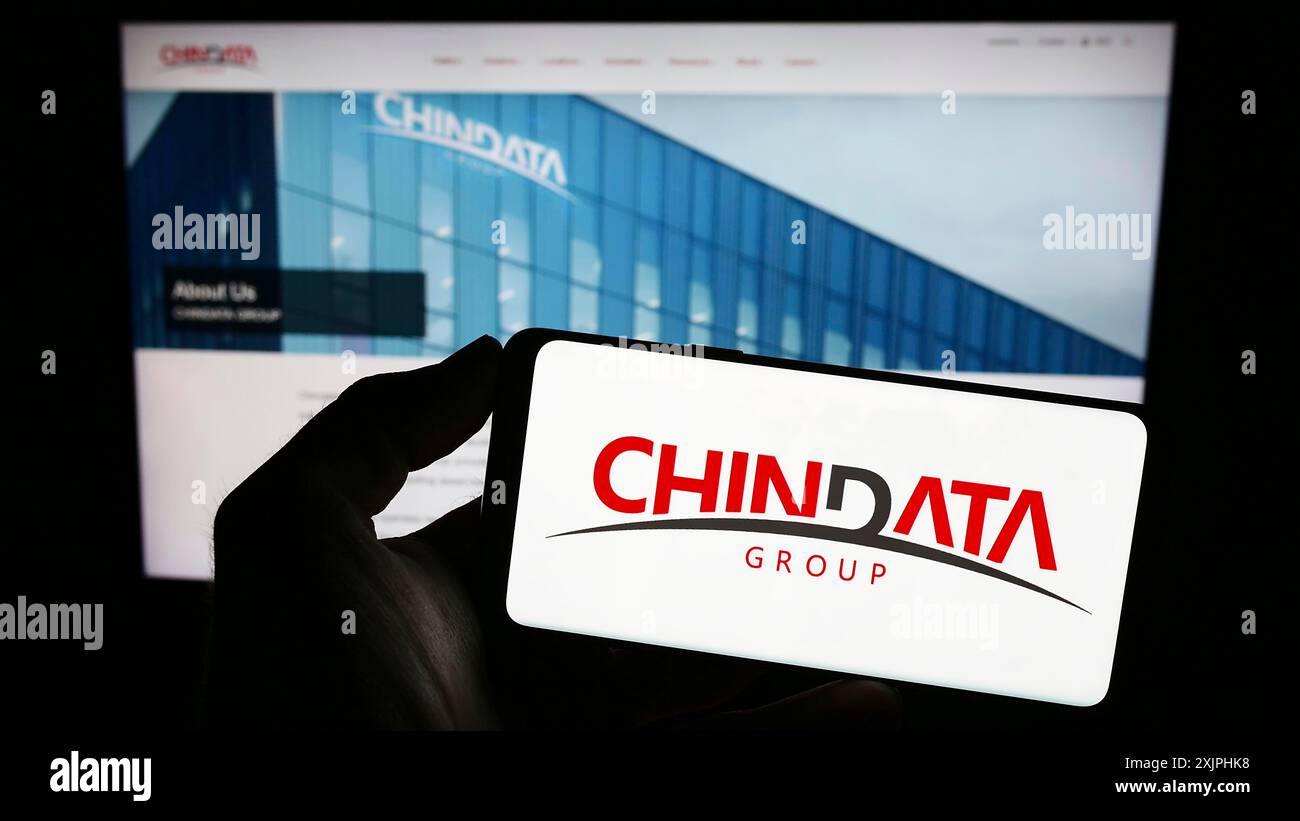 Stuttgart, Allemagne, 06-24-2023 : personne tenant un téléphone portable avec le logo de la société chinoise de centre de données Chindata Group sur l'écran devant la page Web. Banque D'Images