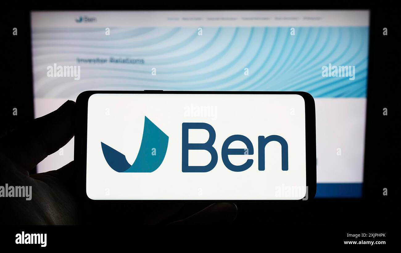 Stuttgart, Allemagne, 06-24-2023 : personne tenant un smartphone avec le logo du Beneficient Company Group (Trustben) sur l'écran devant le site Web. Mise au point Banque D'Images