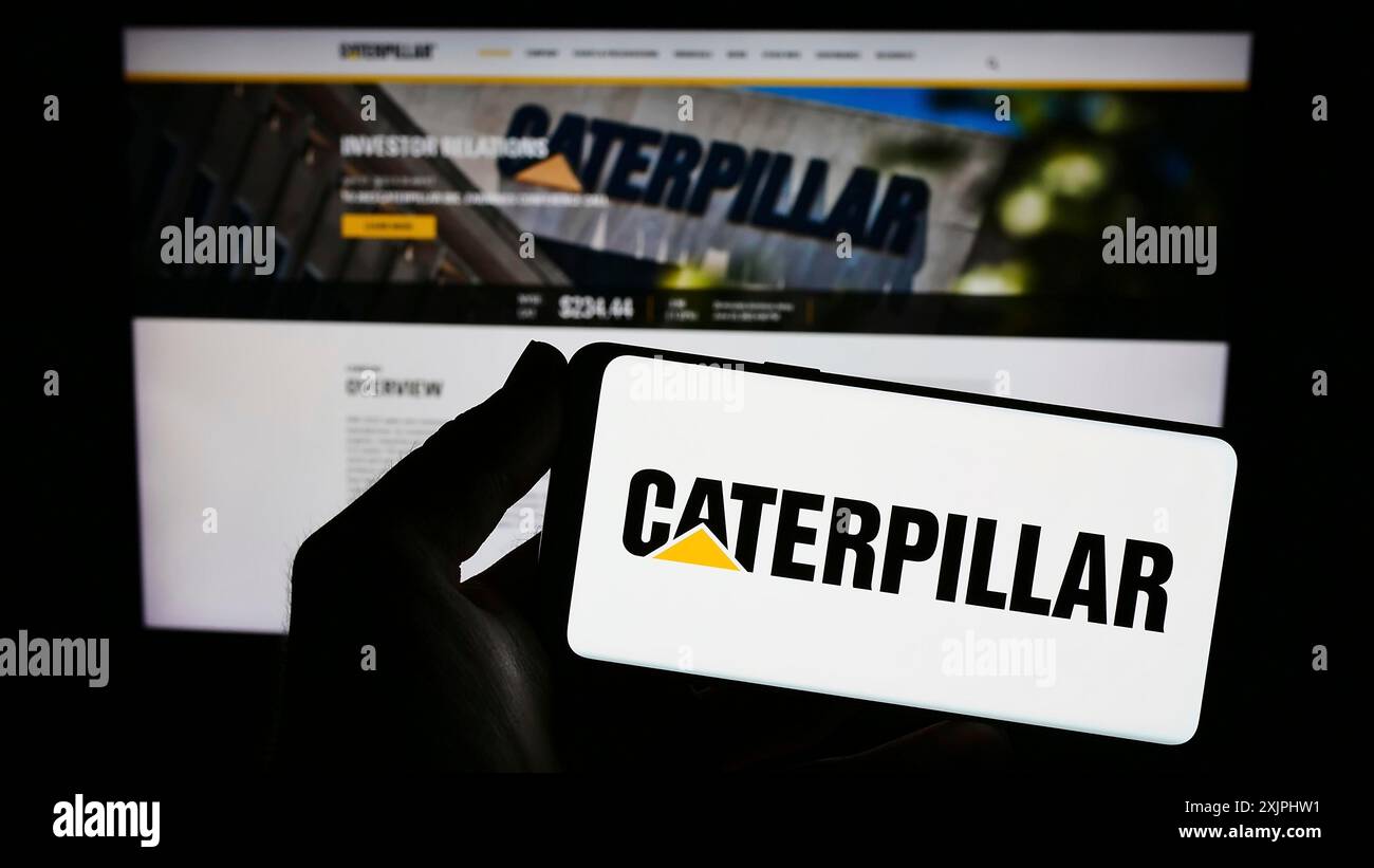 Stuttgart, Allemagne, 06-25-2023, personne tenant un smartphone avec le logo de la société américaine d'équipement lourd Caterpillar Inc sur l'écran devant le site Web. Banque D'Images