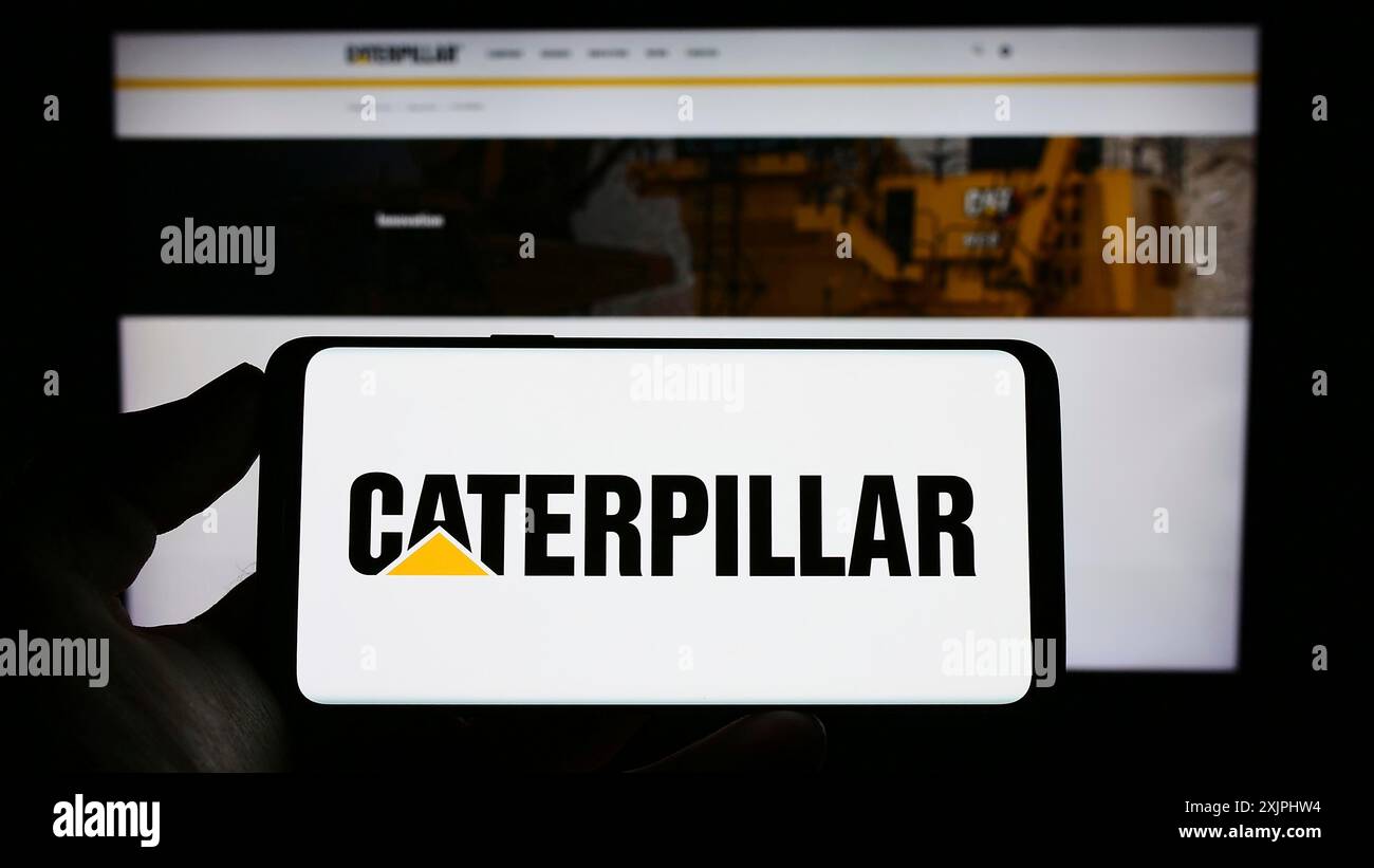 Stuttgart, Allemagne, 06-25-2023, personne tenant un téléphone portable avec le logo de la société américaine d'équipement lourd Caterpillar Inc sur l'écran devant le web Banque D'Images