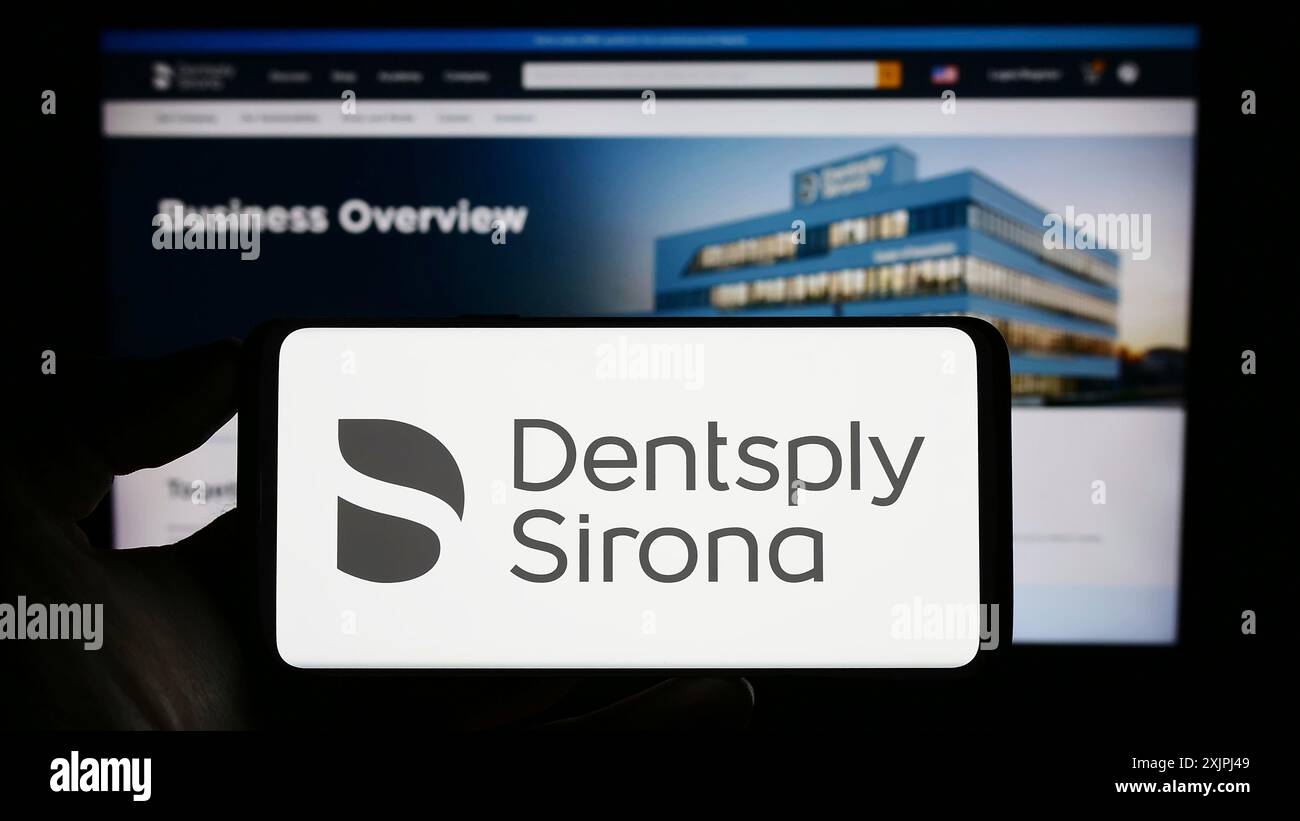 Stuttgart, Allemagne, 06-28-2023, personne tenant un smartphone avec le logo de la société américaine d'équipement dentaire Dentsply Sirona Inc. sur l'écran devant Banque D'Images