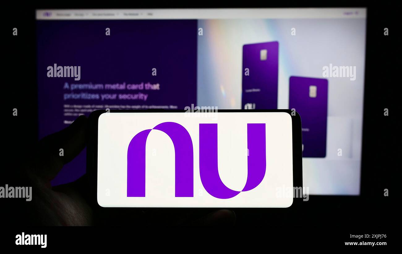 Stuttgart, Allemagne, 06-30-2023, personne tenant un smartphone avec le logo de la société brésilienne Nu Pagamentos S.A. (Nubank) sur l'écran devant le site. Banque D'Images