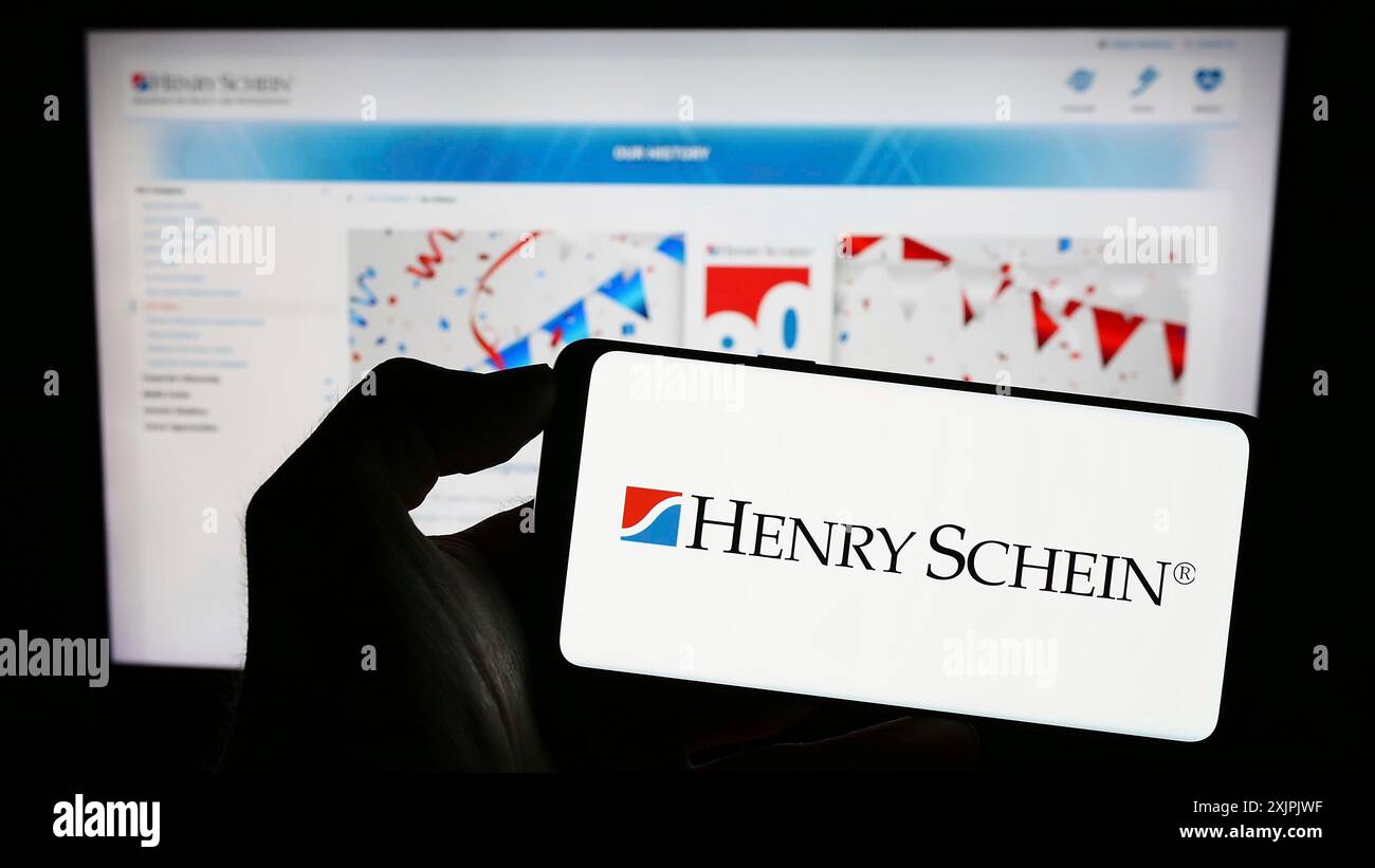 Stuttgart, Allemagne, 07-02-2023 : personne tenant un smartphone avec le logo de la société américaine de produits de santé Henry Schein Inc sur l'écran devant Banque D'Images