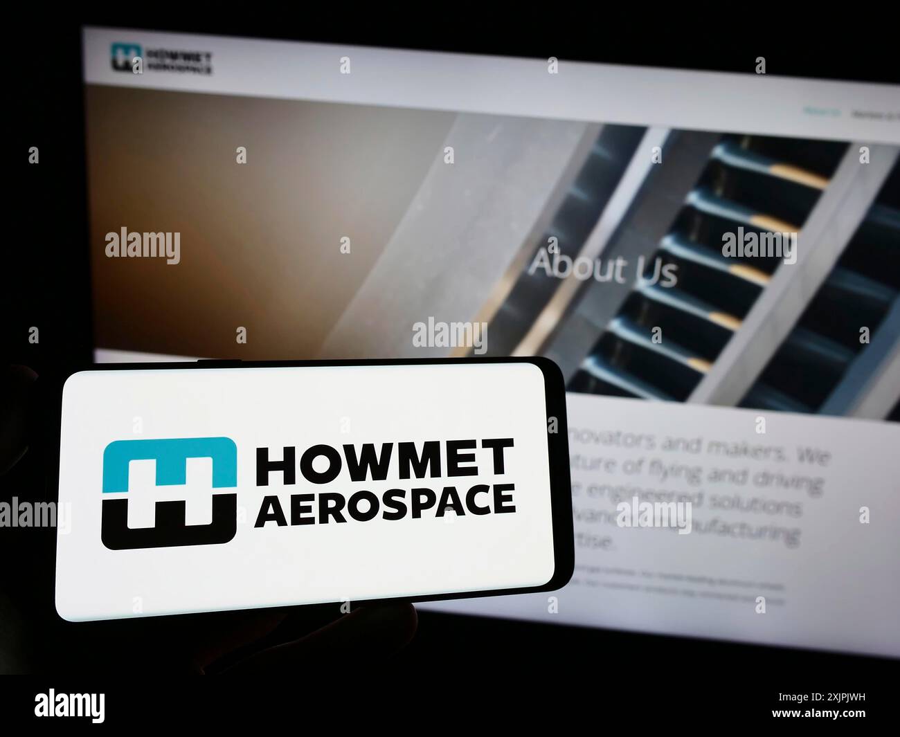 Stuttgart, Allemagne, 07-02-2023 : personne tenant un smartphone avec le logo de la société américaine Howmet Aerospace Inc sur l'écran devant le site. Concentrez-vous sur le téléphone Banque D'Images