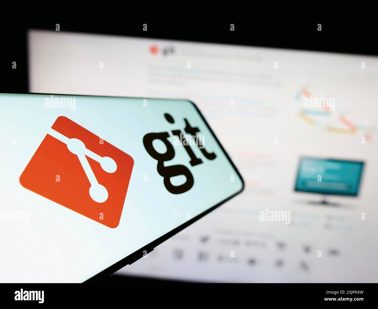 Stuttgart, Allemagne, 07-09-2023 : téléphone portable avec le logo du système de contrôle de version distribué Git sur l'écran devant le site Web. Focus à gauche de Banque D'Images