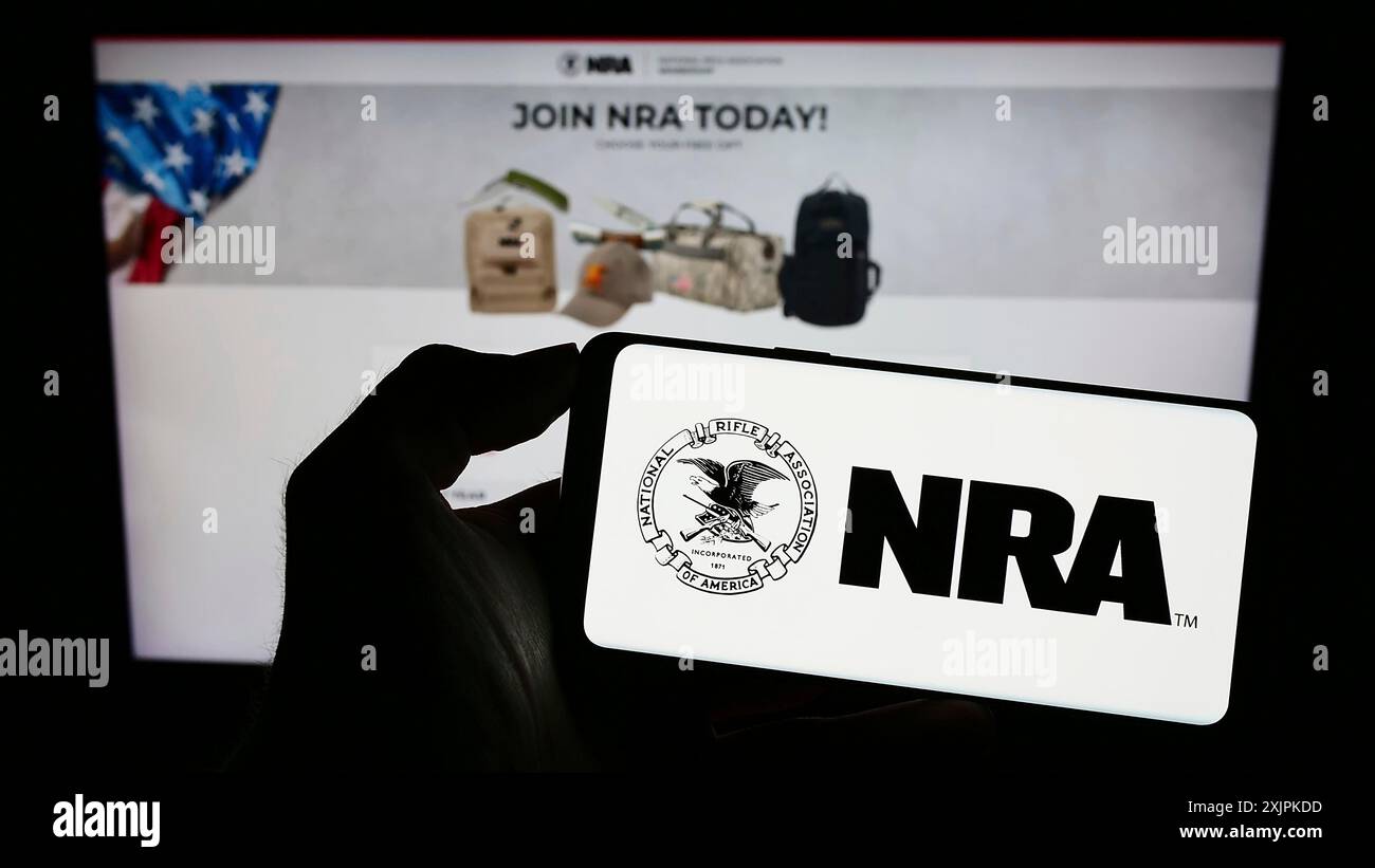 Stuttgart, Allemagne, 07-09-2023 : personne tenant un téléphone portable avec le logo de la National Rifle Association of America (NRA) sur l'écran devant la page web. Banque D'Images