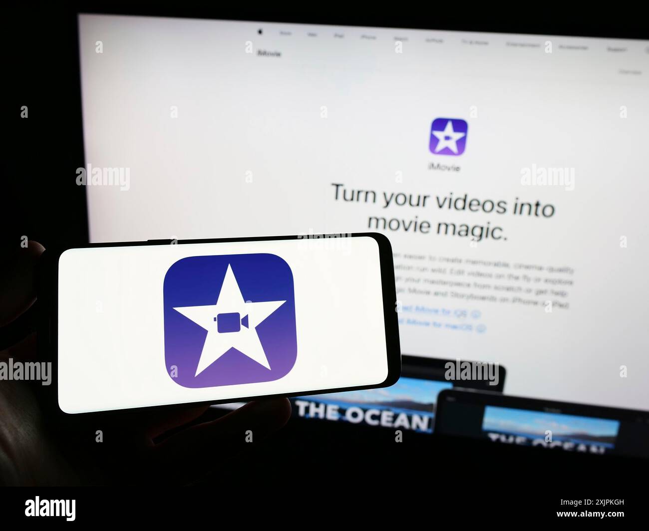 Stuttgart, Allemagne, 07-12-2023 : personne tenant un smartphone avec le logo du logiciel de montage vidéo iMovie (Apple Inc) sur l'écran devant le site Web. Banque D'Images