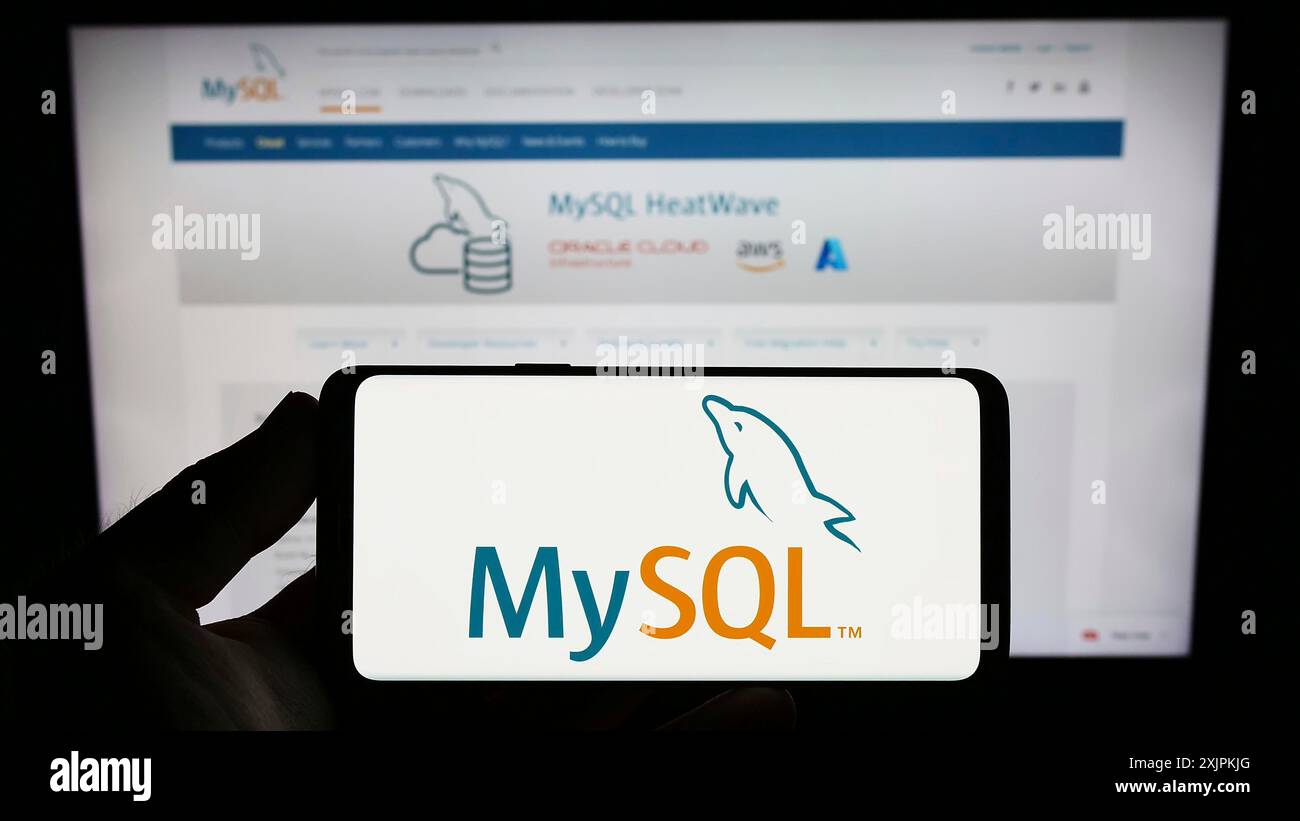 Stuttgart, Allemagne, 07-13-2023 : personne tenant un smartphone avec le logo du système de gestion de base de données relationnelle MySQL sur l'écran devant le site Web. Banque D'Images Stuttgart, Allemagne, 07-13-2023 : personne tenant un smartphone avec le logo du système de gestion de base de données relationnelle MySQL sur l'écran devant le site Web. Banque D'Images