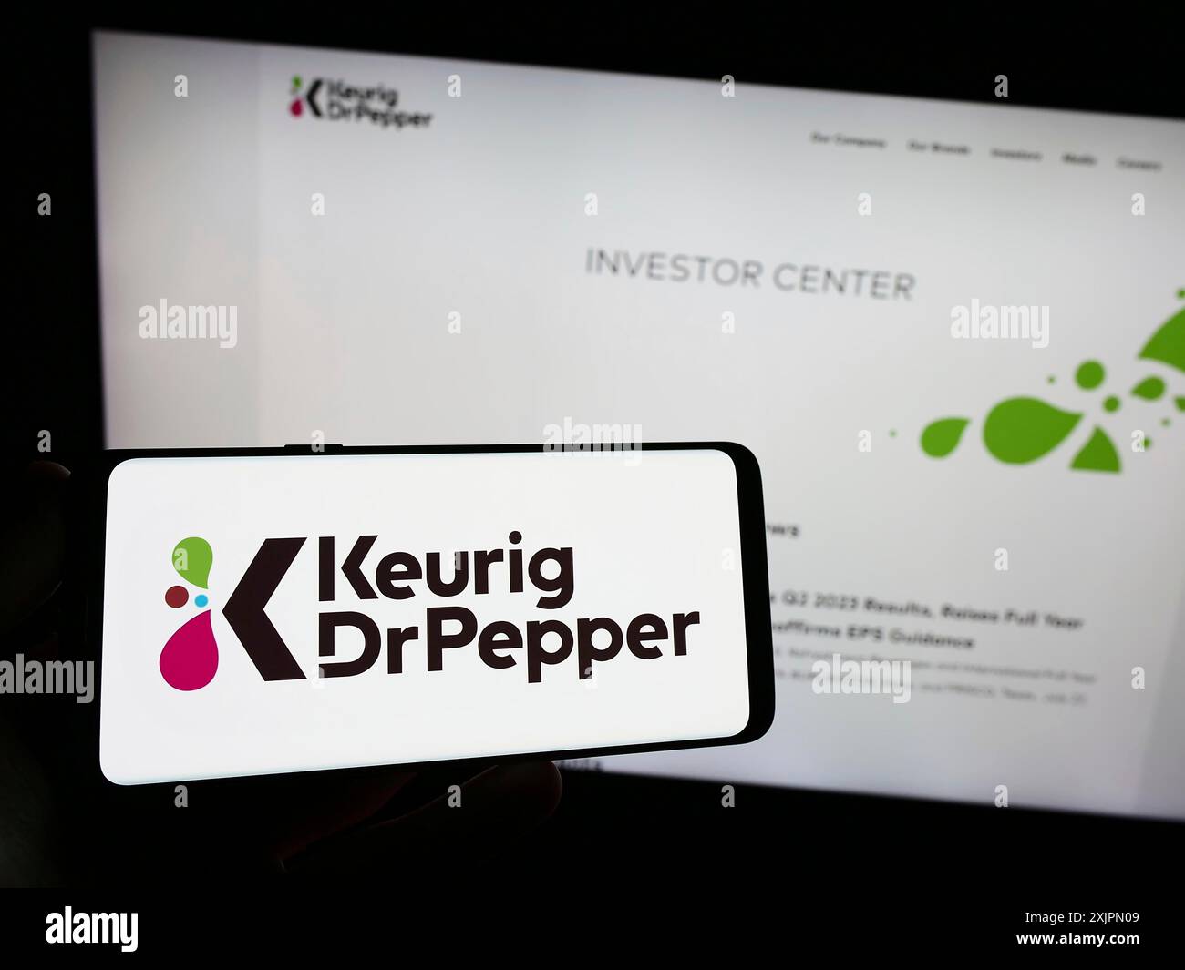 Stuttgart, Allemagne, 07-30-2023, personne tenant un smartphone avec le logo de la société américaine de boissons Keurig Dr Pepper Inc. sur l'écran devant le site Web. Mise au point Banque D'Images