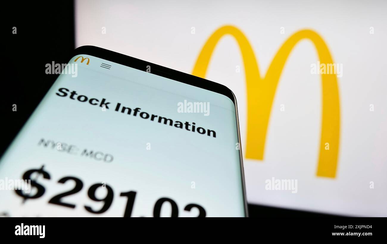 Stuttgart, Allemagne, 08-04-2023 : smartphone avec la page Web de la société américaine de restauration rapide McDonald's Corporation sur l'écran devant le logo de l'entreprise. Concentrez-vous sur Banque D'Images