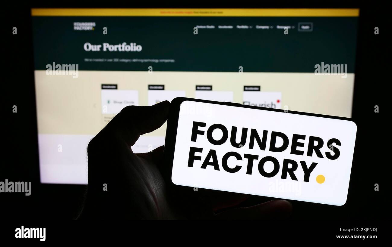 Stuttgart, Allemagne, 08-05-2023 : personne tenant un téléphone portable avec le logo de la société britannique Founders Factory Ltd sur l'écran devant le web d'affaires Banque D'Images