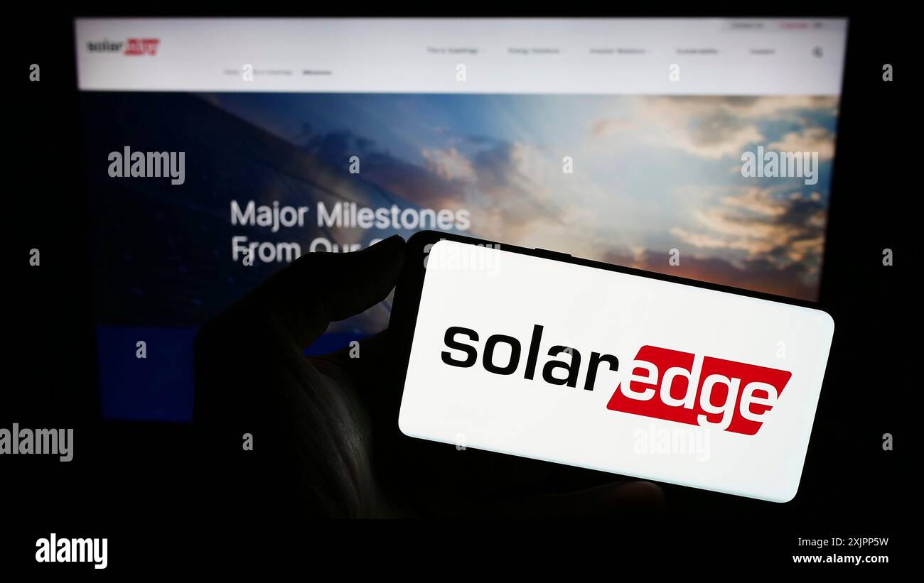 Stuttgart, Allemagne, 08-08-2023 : personne tenant un téléphone portable avec le logo de la société israélienne SolarEdge technologies Inc sur l'écran devant l'entreprise Banque D'Images
