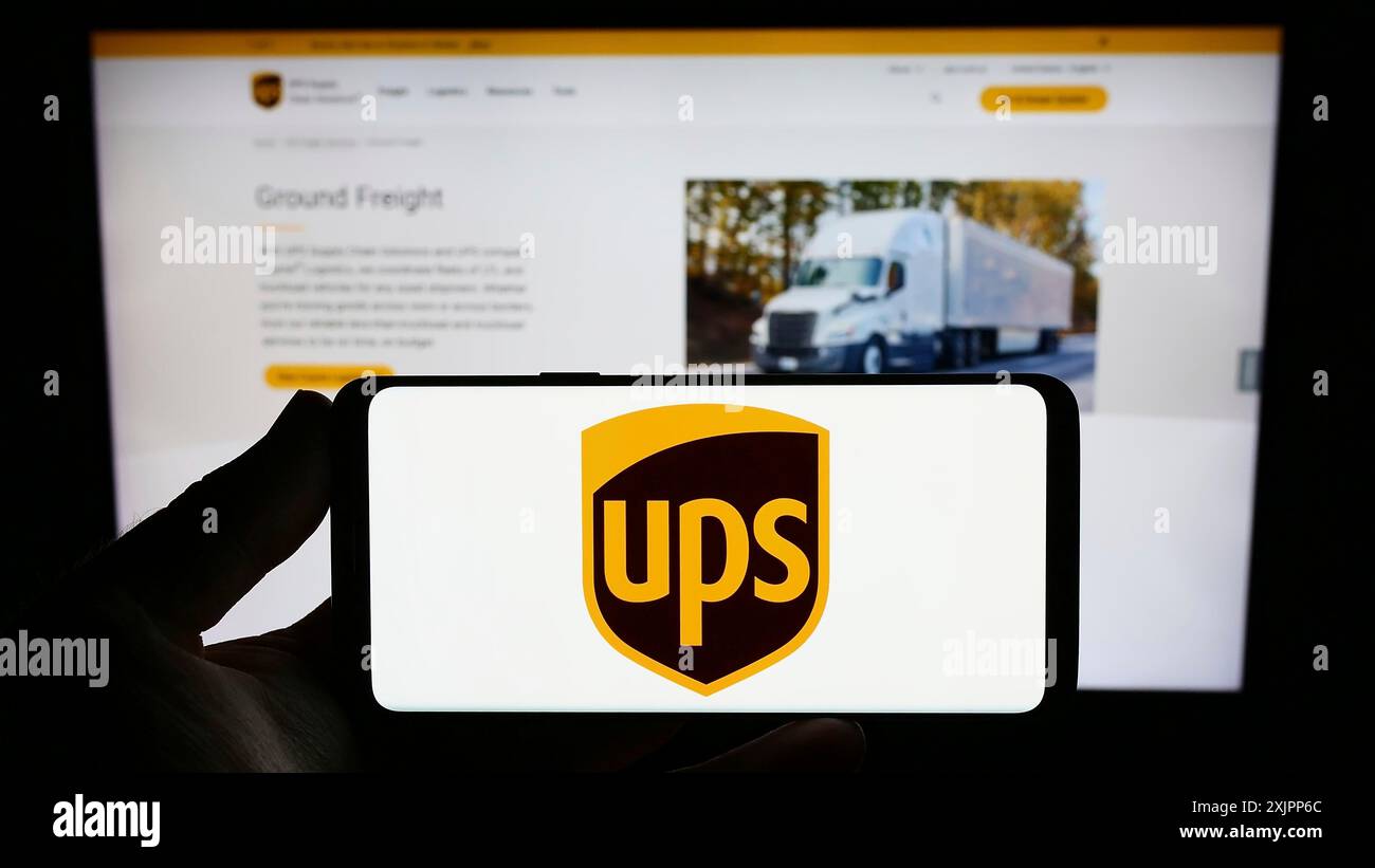 Stuttgart, Allemagne, 08-11-2023 : personne tenant un smartphone avec le logo de la société américaine United Parcel Service Inc (UPS) sur l'écran devant le site Web. Banque D'Images