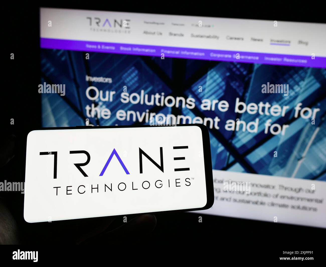 Stuttgart, Allemagne, 08-11-2023 : personne tenant un téléphone portable avec le logo de la société irlandaise Trane technologies plc sur l'écran devant la page Web de l'entreprise. Banque D'Images