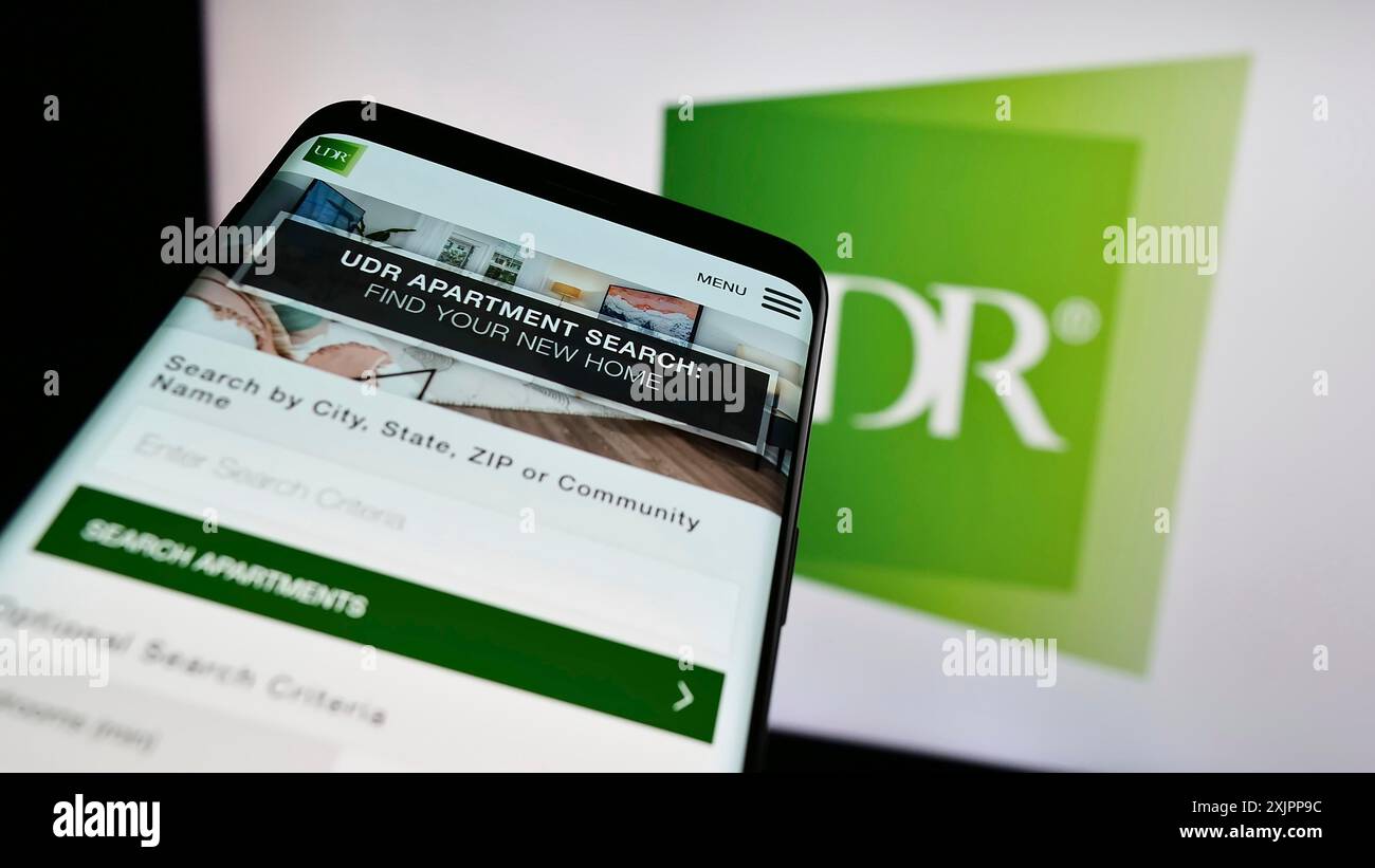 Stuttgart, Allemagne, 08-11-2023 : smartphone avec le site web de la société immobilière américaine UDR Inc sur l'écran devant le logo de l'entreprise. Concentrez-vous sur le coin supérieur gauche de Banque D'Images