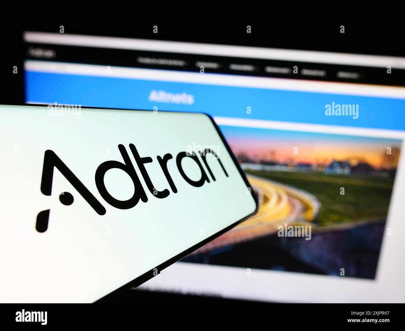 Stuttgart, Allemagne, 08-20-2023 : téléphone portable avec le logo de la société américaine de télécommunications Adtran Inc sur l'écran devant le site. Concentrez-vous sur Banque D'Images