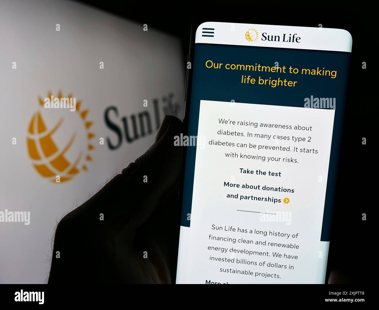Stuttgart, Allemagne, 09-14-2023 : personne tenant un téléphone cellulaire avec le site Web de la société canadienne financière Sun Life Inc sur l'écran devant le logo. Mise au point Banque D'Images