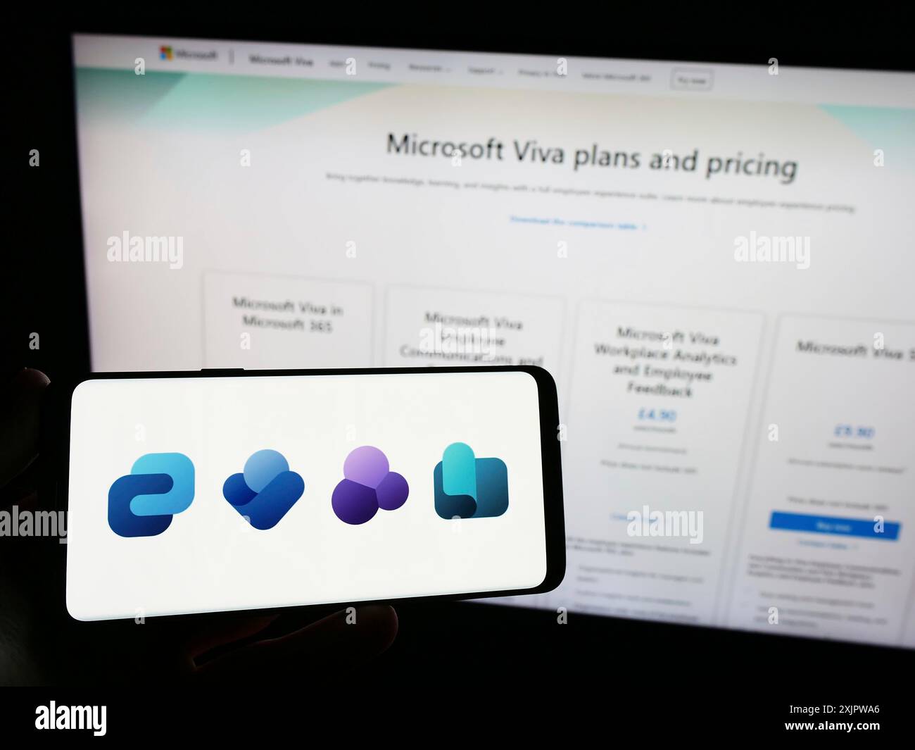 Stuttgart, Allemagne, 09-22-2023 : personne tenant un téléphone portable avec le logo de la plate-forme d'expérience des employés Microsoft Viva sur l'écran en face de la page Web. Banque D'Images